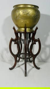 A Chinese Bronze Jardiniere: With a wood stand. The jardiniere measures 11 in. high, 15 in. wide; 34 in. high overall.
