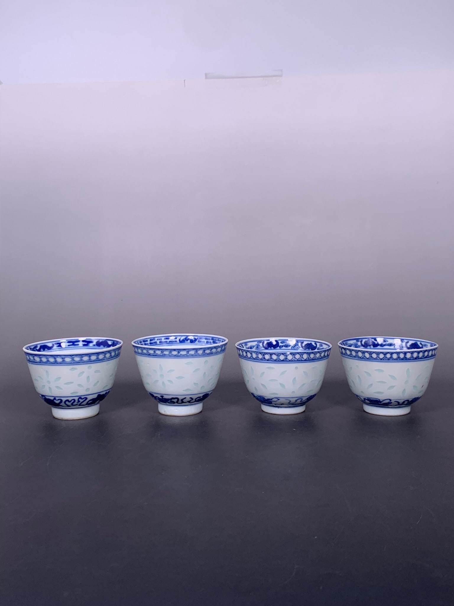 A Group of Four Chinese Blue and White 'Rice Pattern' Cups, Xiang He Qi Zhen Marks (1 of 15)