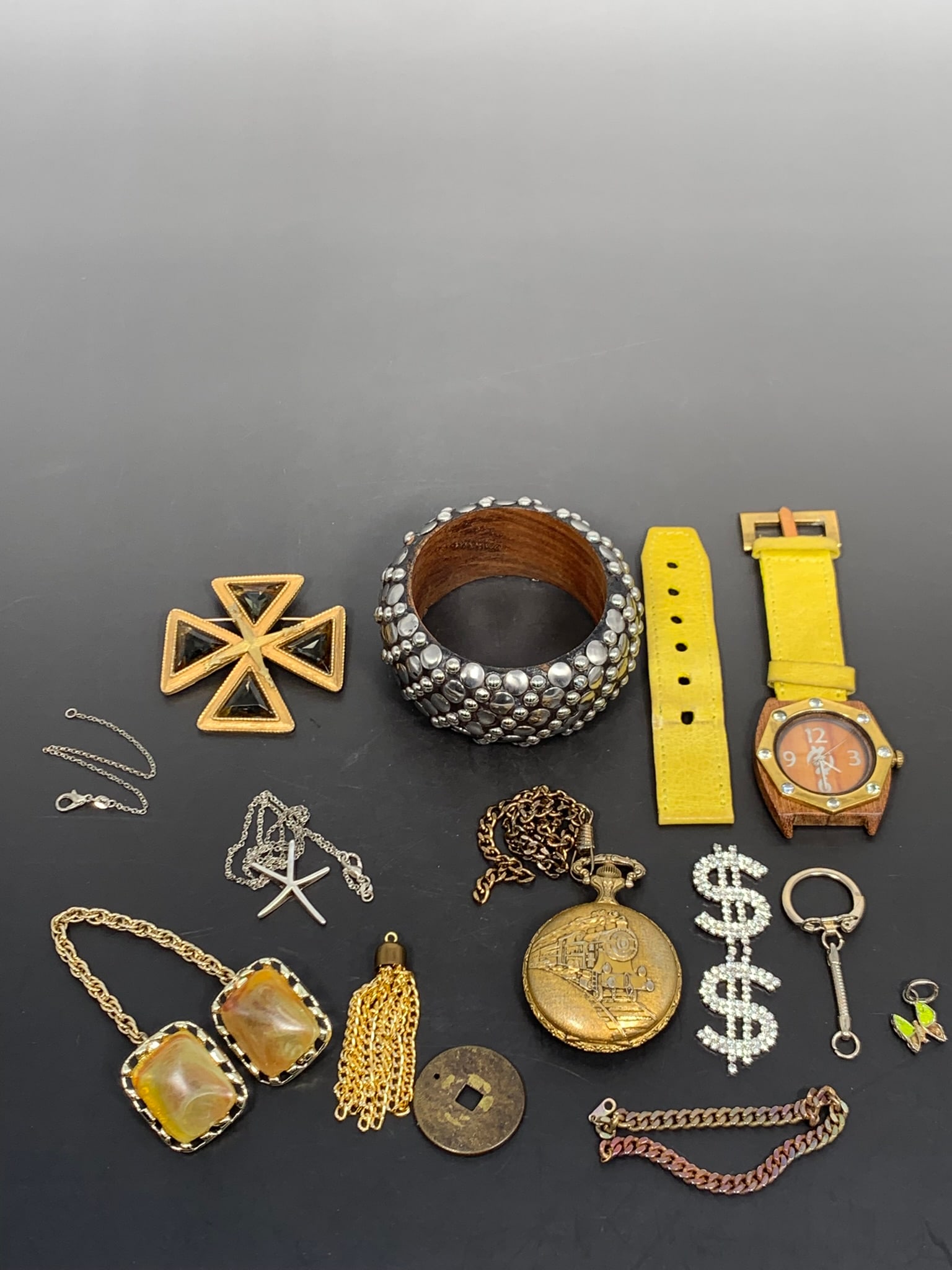 A Group of Six Decorative Objects: Comprising a Majestron pocket watch, 1.7/8 in. diam. for the dial; a wrist watch, 1.3/4 in. wide for the dial; a wooden dotted brass bangle, 3.1/2 in. diam., 1.1/2 in. wide; a vintage glass cross broo