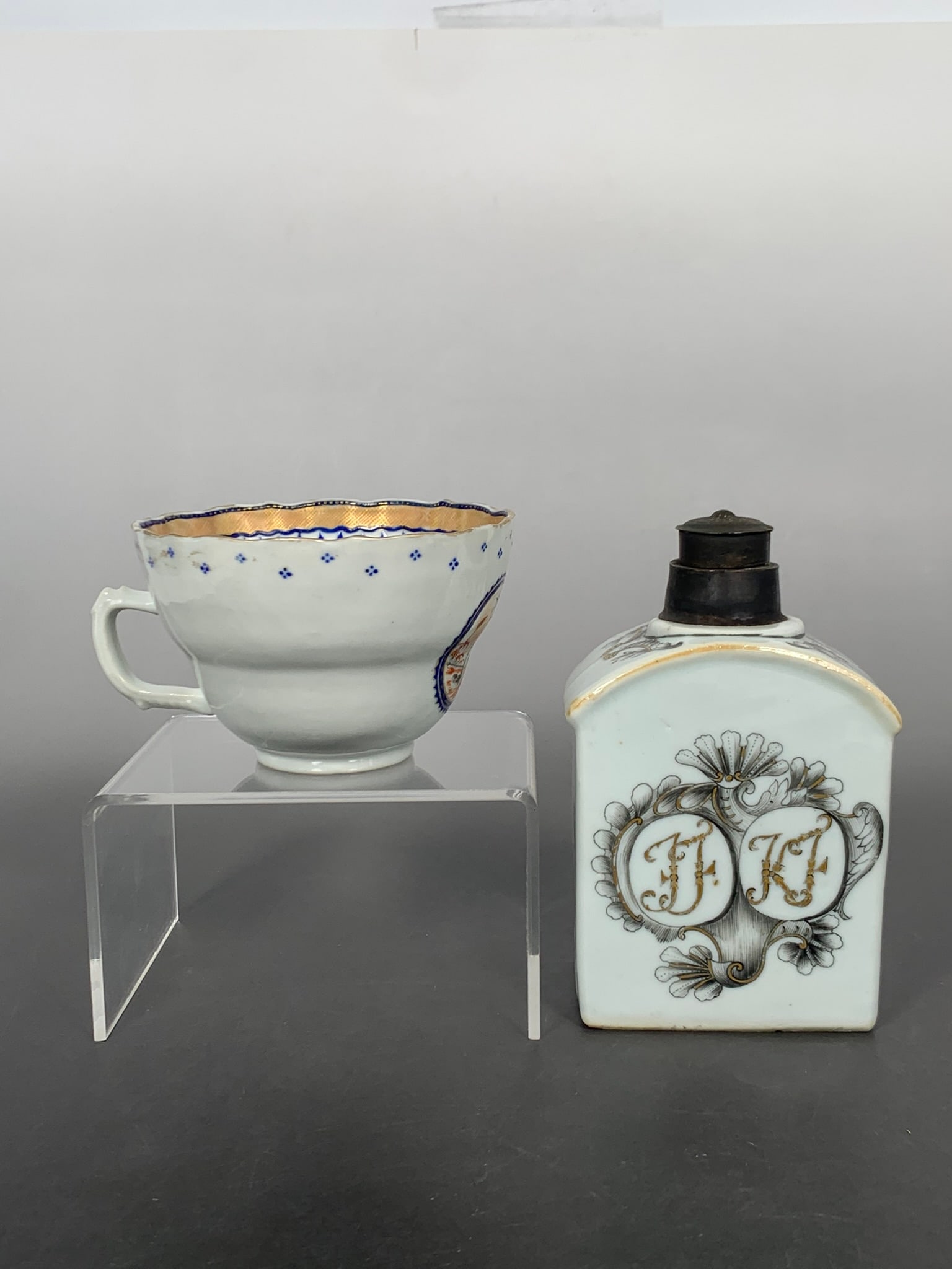 Two Chinese Export Tea Wares, Qianlong Period, Qing Dynasty: Comprising a tea caddy, the mouth is wrapped by metal, with a metal cover, 4.7/8 in. high, 3 in. wide; and a tea cup, 2.3/8 in. high, 4.1/4 in. wide.