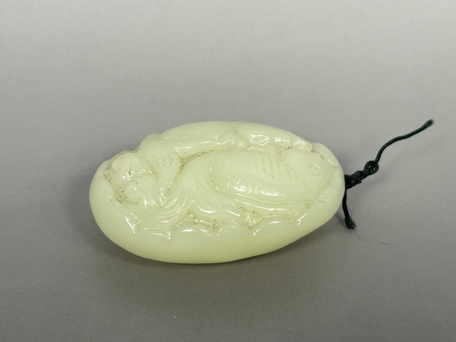 A Chinese Carved Celadon Jade 'Twin Fish' Pendant: 2.5/8 in. high, 1.7/8 in. wide.