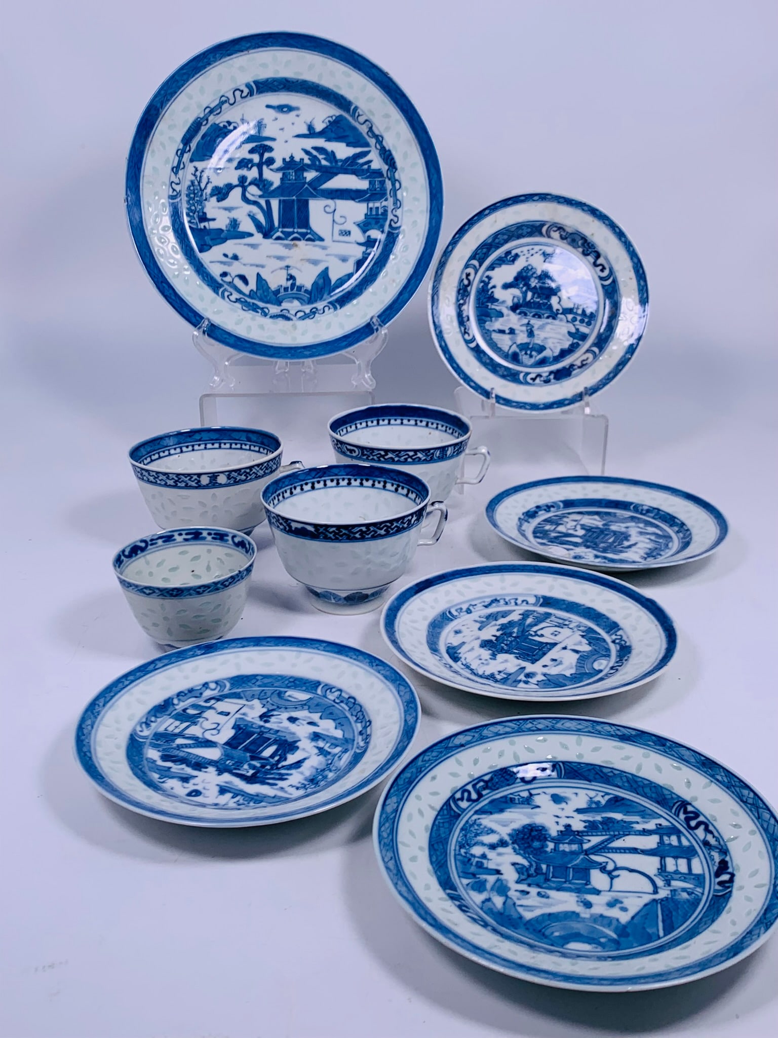 A Group of Ten Chinese Blue and White 'Rice-Pattern' Ware: Comprising three handled tea cups, 2.3/4 in. high, 4.3/8 in. wide each; a smaller tea cup without handle, 2 in. high, 2.7/8 in. diam.; a larger dish, 8.5/8 in. diam.; and five smaller dishes, 6 in. di