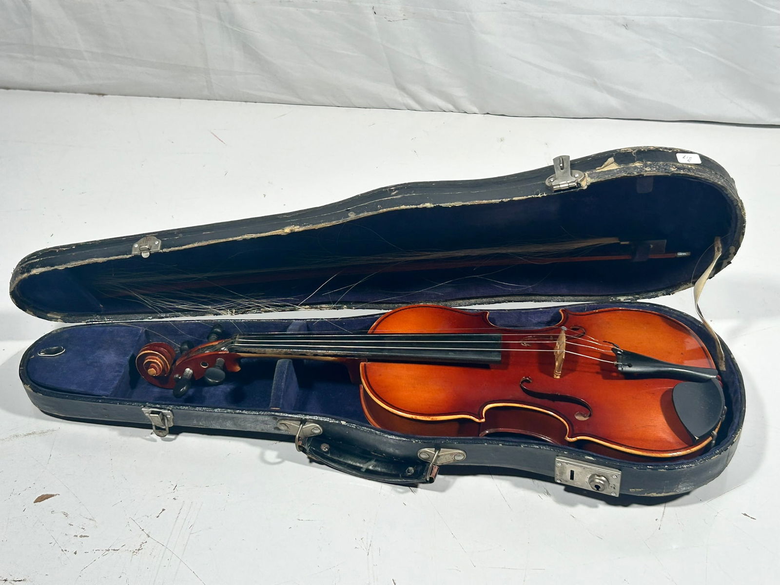 A Vintage Violin: With a carrying case. 21 in. long, 7.1/2 in. wide for the violin; 3.1/2 in. high, 26 in. wide, 8.1/4 in. deep for the carrying case.