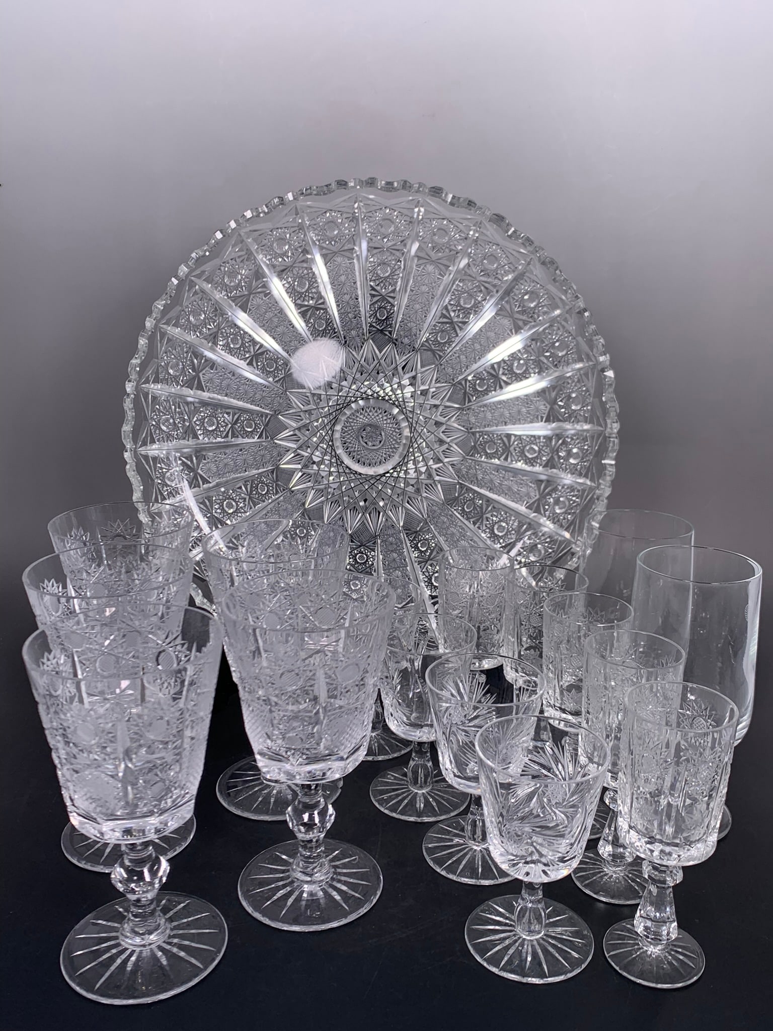 A Group of Seventeen Cut Crystal/Glass Ware: Comprising a cut crystal circular serving tray, 11.1/2 in. diam.; a set of five cut crystal wine glasses, 5.3/8 in. high, 2.3/4 in. wide each; a set of five smaller cut crystal wine glasses, 4.1/2 in.