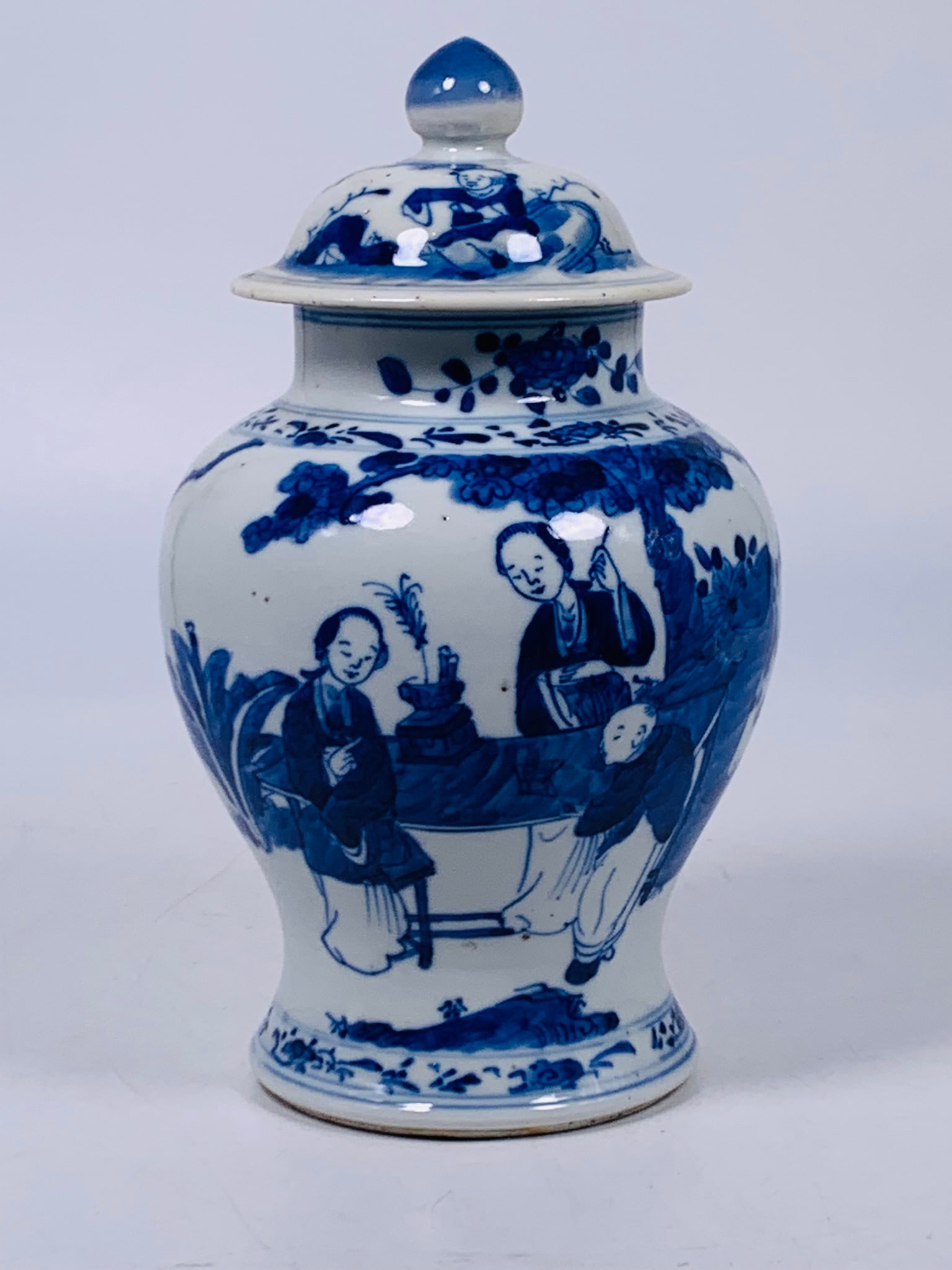 A Chinese Small Blue and White 'Ladies and Boy' Jar and Cover, Qing Dynasty: 9 in. high, 5 in. wide.