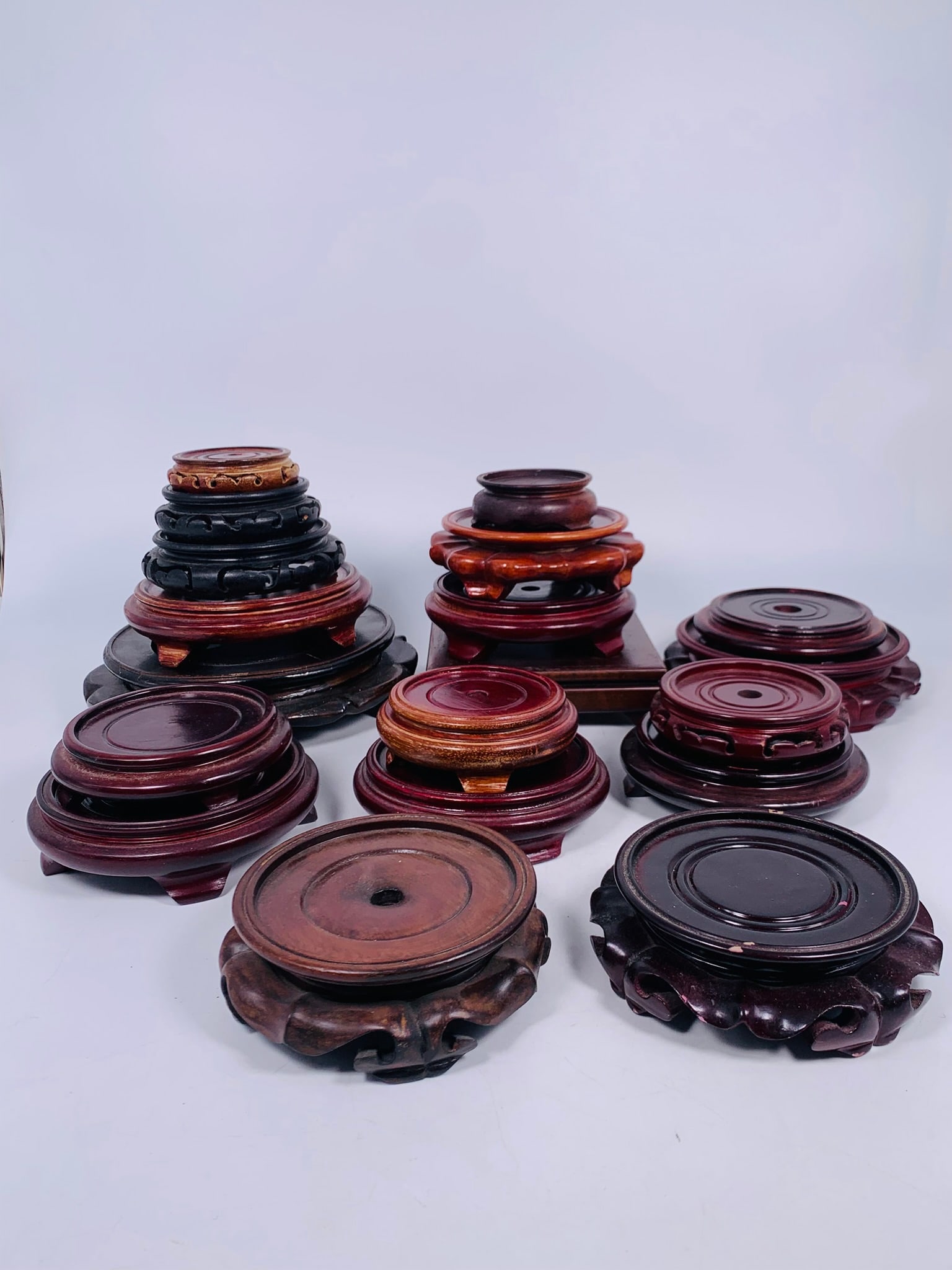 A Group of Twenty-One Chinese Wood Stands and Racks: Comprising ninteen wood stands in various sizes and shapes, with the largest measures 2.1/8 in. high, 8.1/2 in. diam., and the smallest measures 1 in. high, 3.1/4 in. diam.; and two dish racks, the la