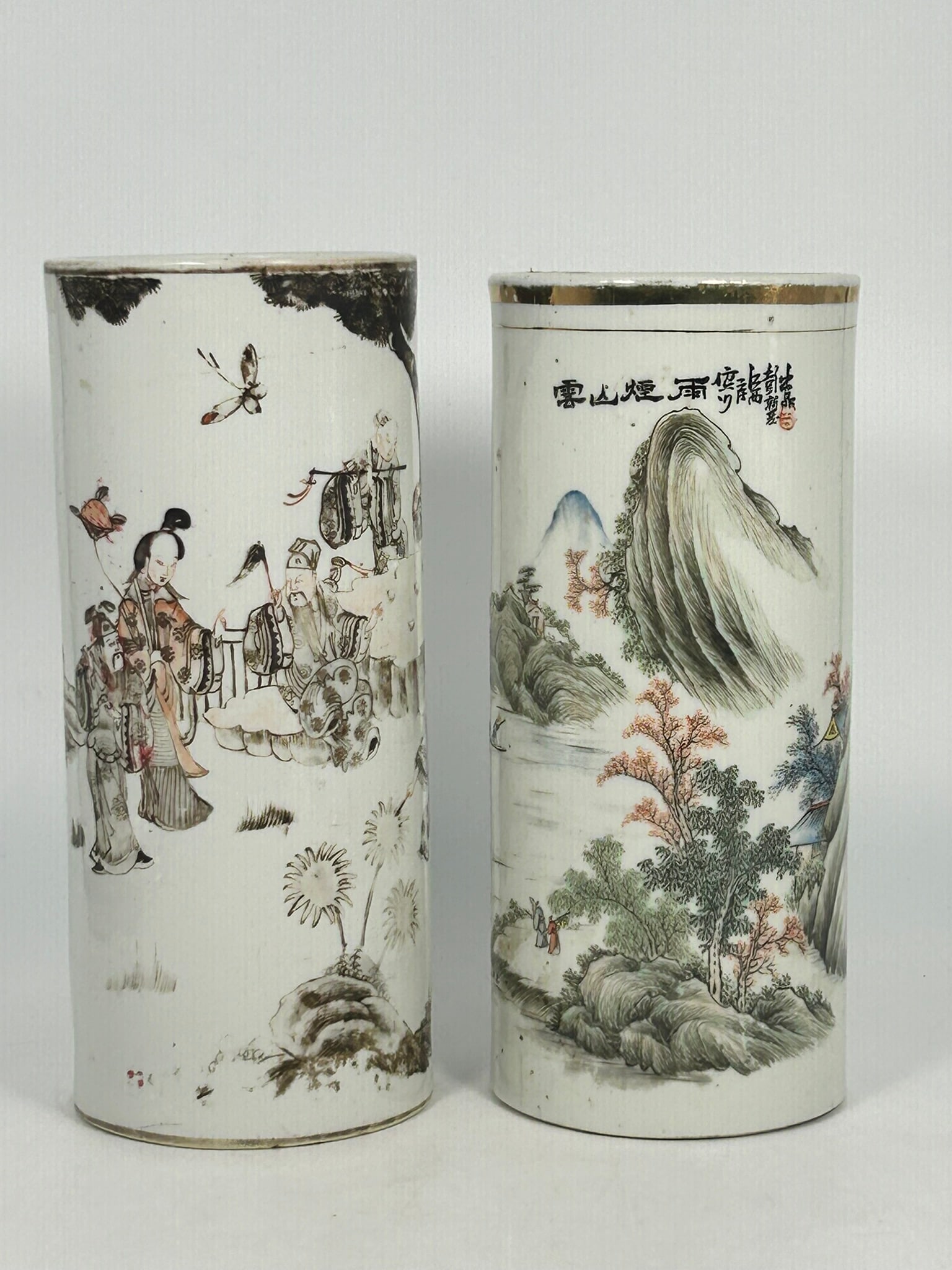 Two Chinese Famille Rose Hat Stands, Late Qing Dynasty/Republic Period: Comprising a 'landscape' hat stand, 11 in. high, 4.3/4 in. diam.; and an 'eight immortals' hat stand, 11.1/4 in. high, 4.3/4 in. diam.