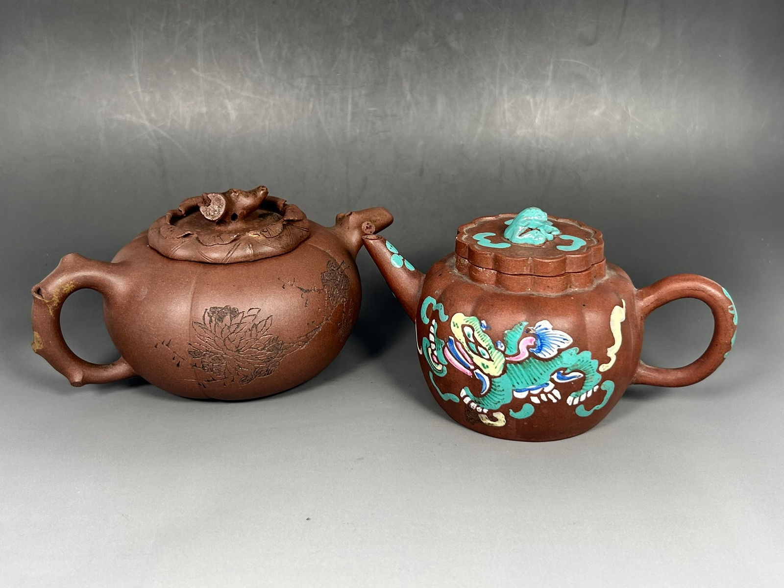 Two Chinese Yixing Pottery Teapots: The larger one with a maker's mark 'Yixing Songting Zi Zao' to the underside of the teapot, and another mark 'He Yong' to the inner side of the cover. 3.3/4 in. high, 7.1/8 in. wide; the other one wit
