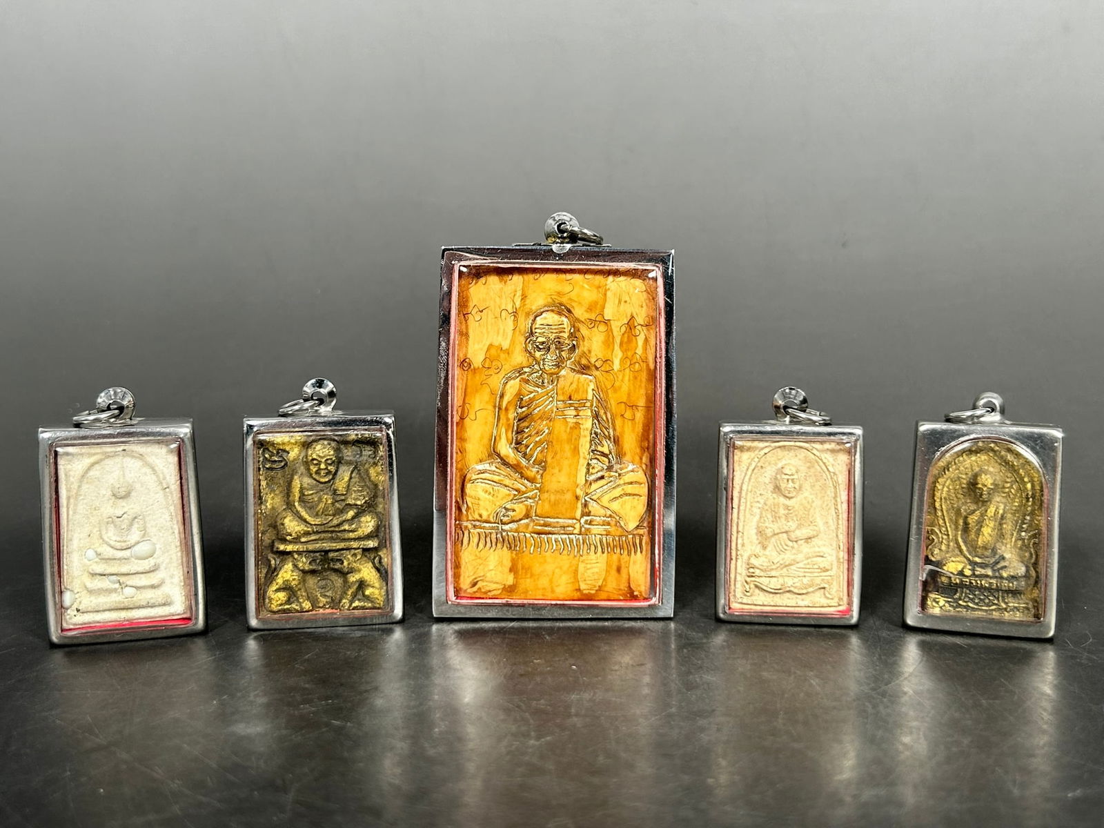 A Group of Five Thai Buddha Amulets: The largest measures 3 in. long, 2 in. wide.