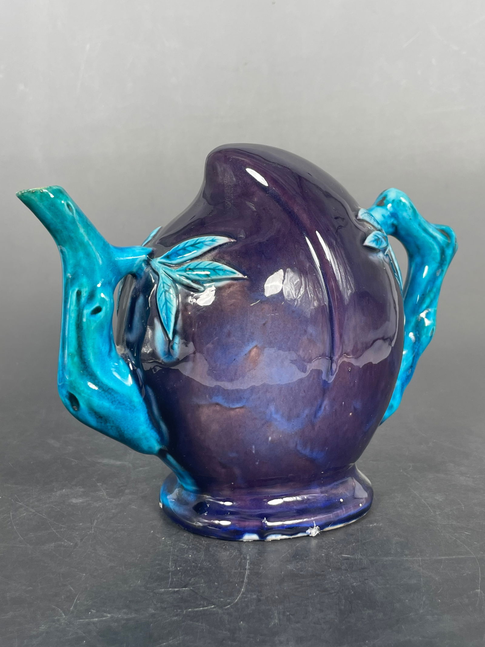 A Chinese Peach-Shaped Monochrome Cadogan Wine Pot, Late Qing Dynasty: 6 in. high, 8 in. wide.