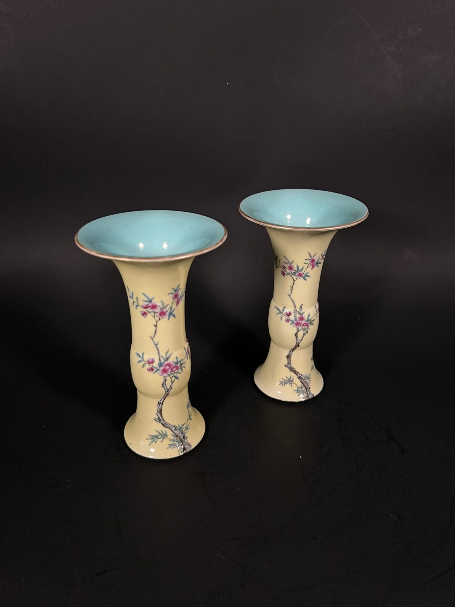 A Pair of Small Famille Rose Yellow-Ground Gu-Form Vases, Late Qing Dynasty/Republic Period: Both depicting plum blossom on the body against yellow ground. 7.25 in. high, 4.1 in. wide each.