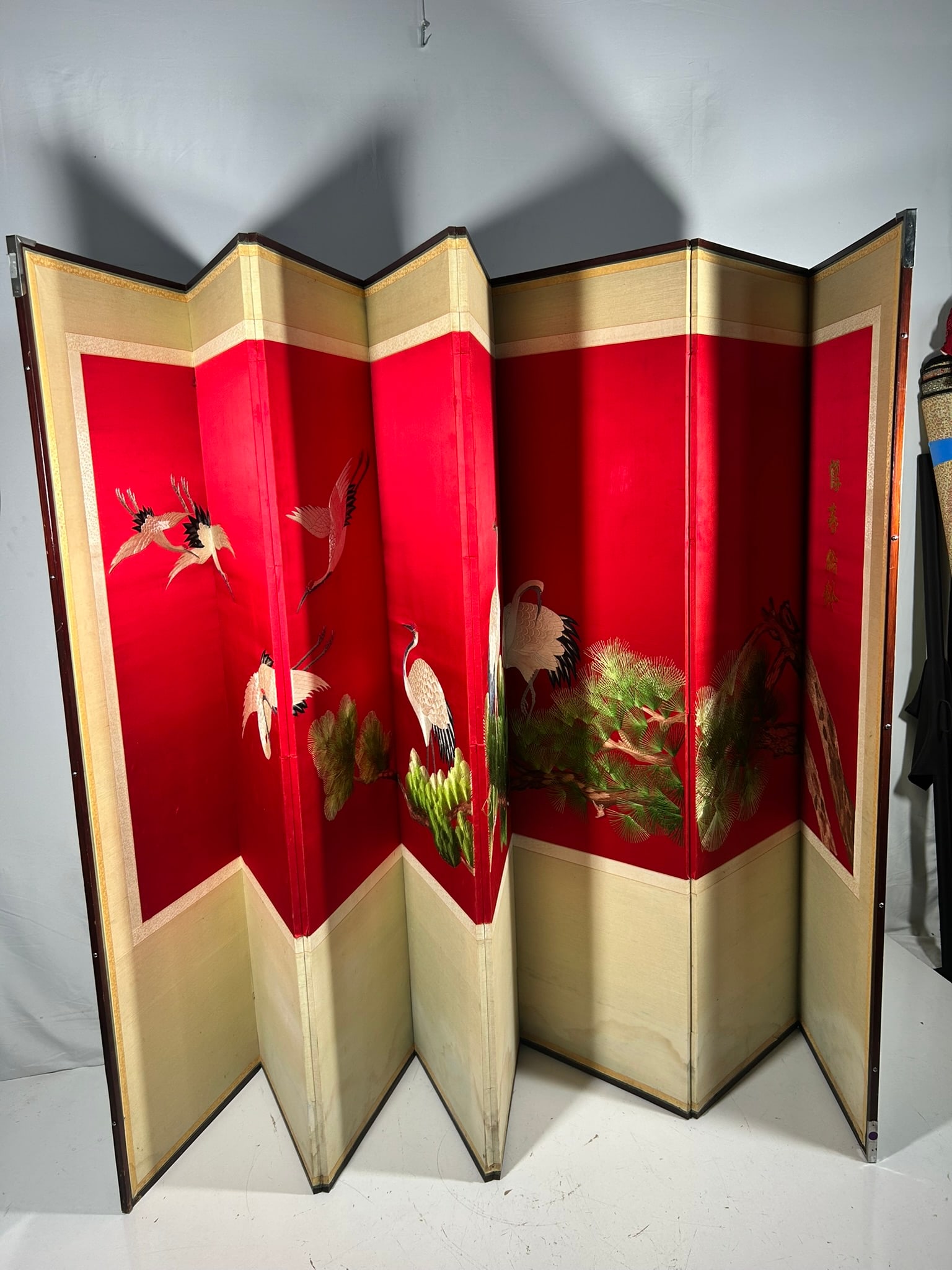 A Chinese Embroidered Silk Eight-Panel Floor Screen: 68.1/2 in. x 18 in. each panel.