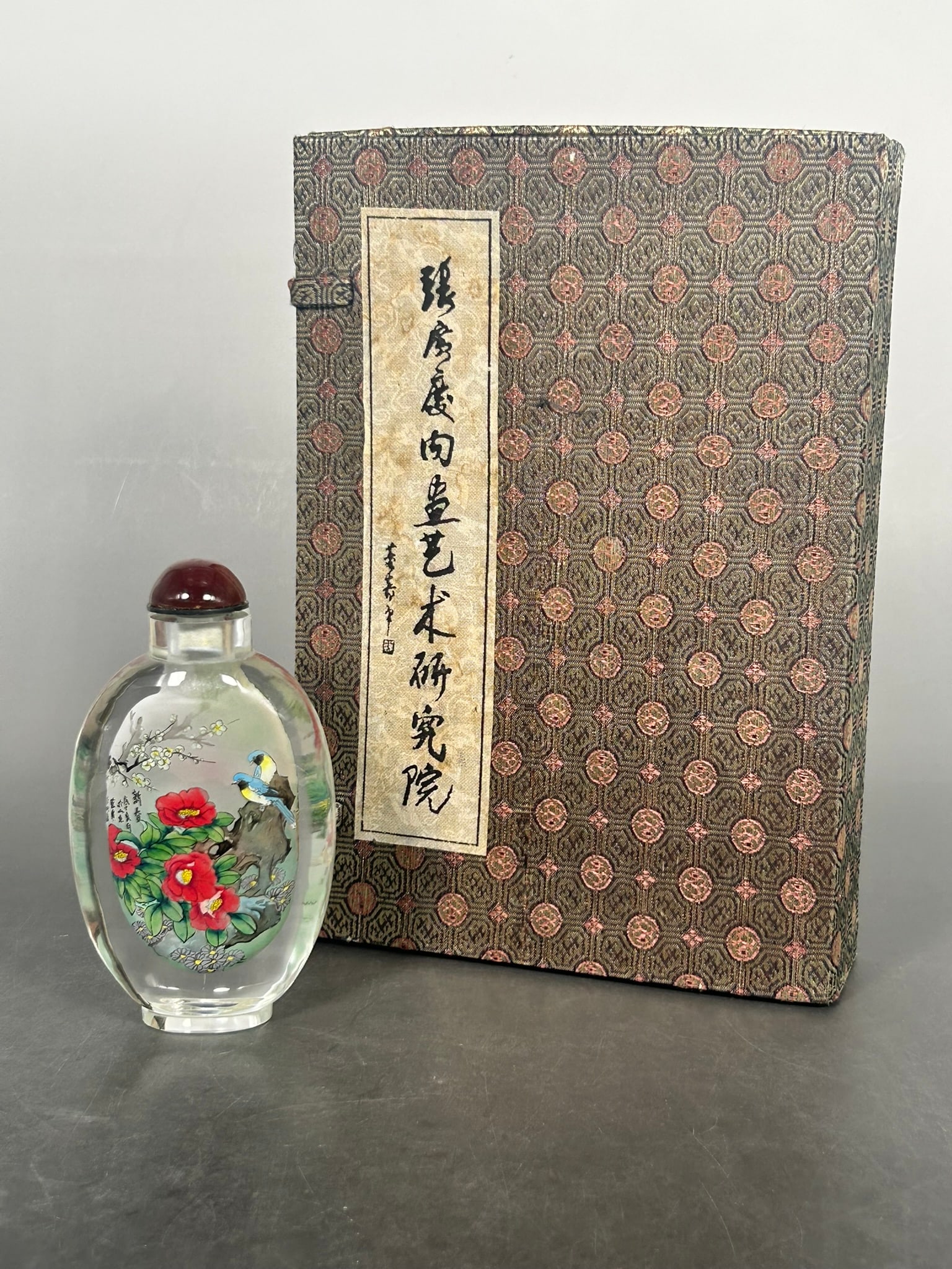 A Chinese Inside-Painted Glass 'Chinese New Year' Snuff Bottle, 2008: The snuff bottle measures 4.7/8 in. high, 2.5/8 in. wide. Dated the year of Wuzi (2008). Come with a certificate issued by the Zhang Guang Qing Inner Drawing Art Research Institute, Shandong, China.