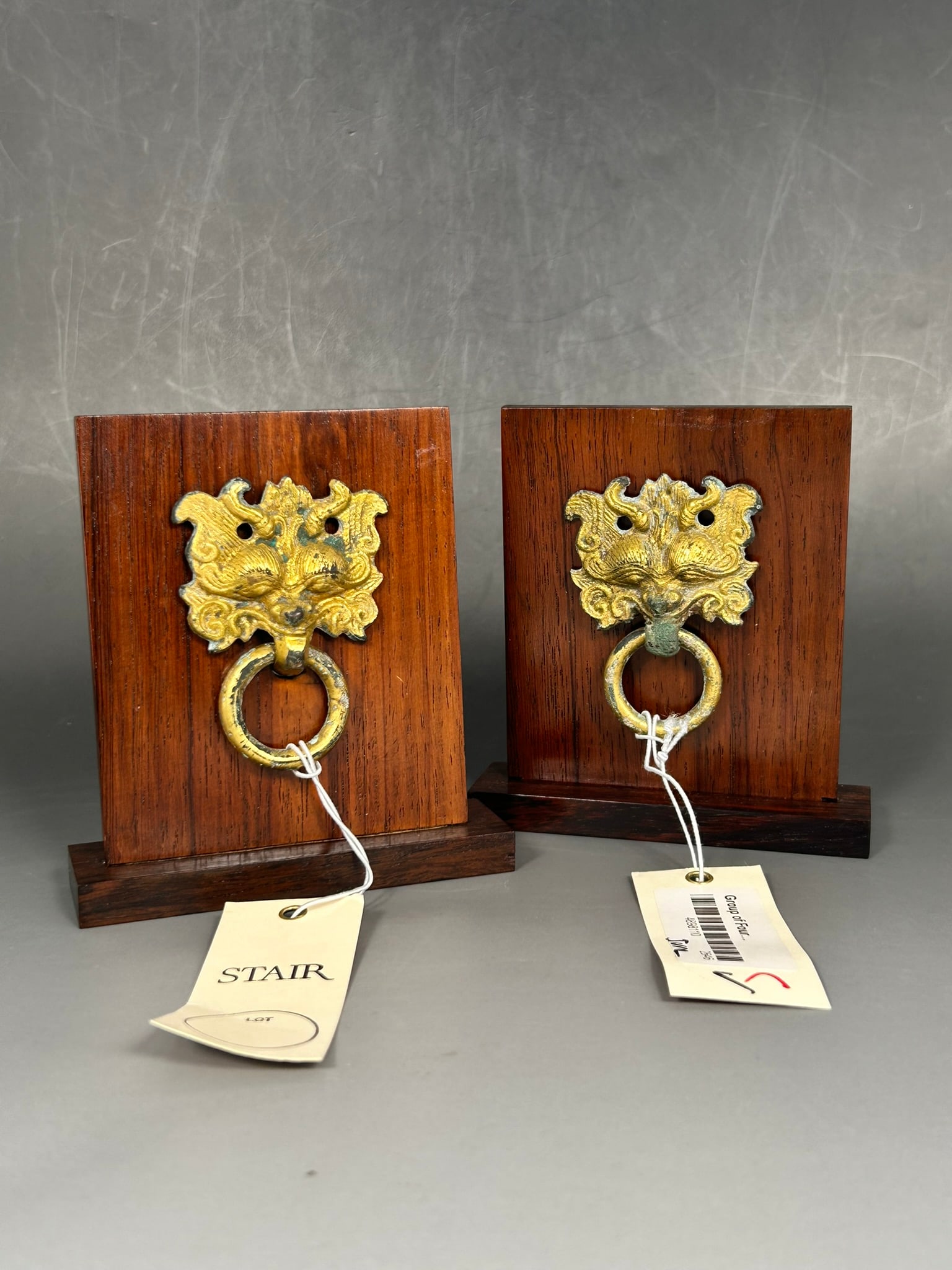 Stair Provenance: A Pair of Chinese Gilt-Bronze Mask and Ring Handles: Both mounted on wood stands, the mask and ring measures 2.3/4 in. high, 2 in. wide each; 4.3/4 in. high, 4.1/8 in. wide overall each. Provenance: The Joukowsky Collection; Stair, 22 June 2023, lot