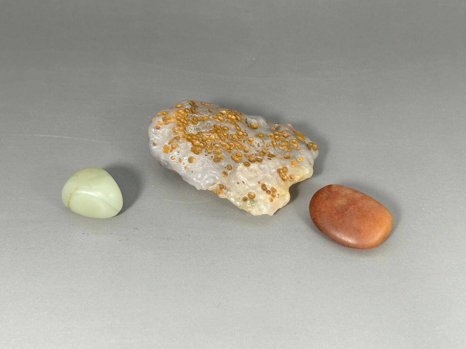 A Group of Three Stone Objects: Comprising a ocean jasper slab, 2.1/2 in. long, 1.3/4 in. wide; and two small stones, with the larger one measures 1 in. long, 3/4 in. wide.