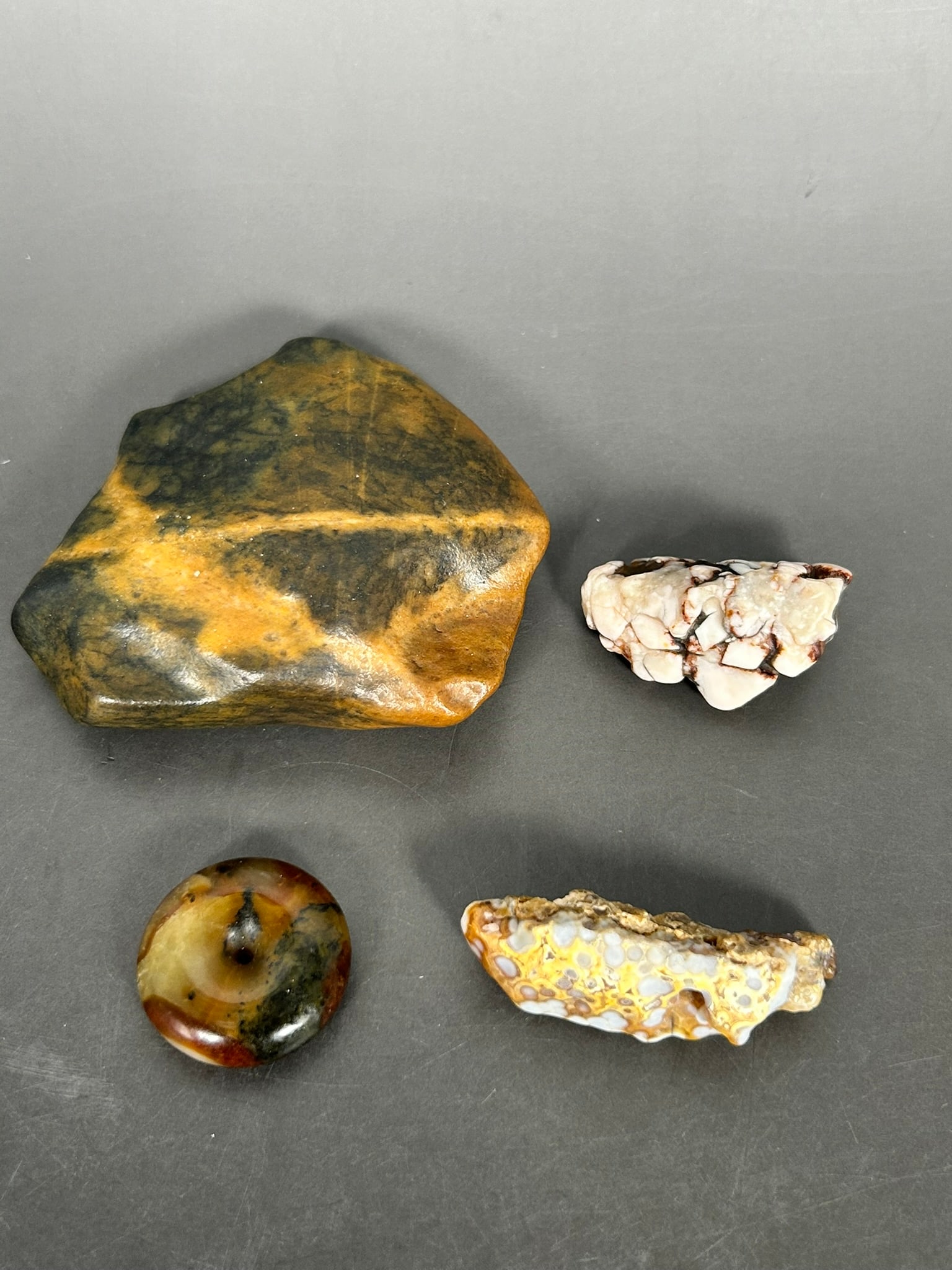 A Group of Four Stone Objects: The largest rock measures 1 in. high, 3.3/4 in. wide.