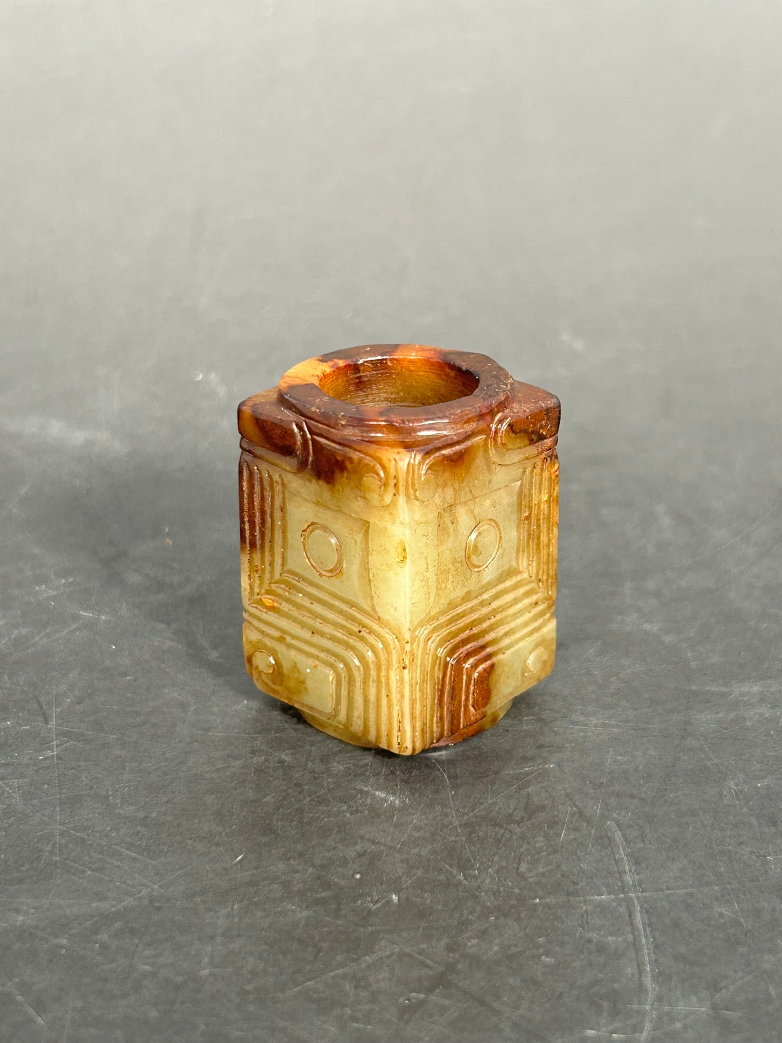 A Chinese Carved Celadon and Russet Jade Cong: 1.5/8 in. high, 1 in. square.