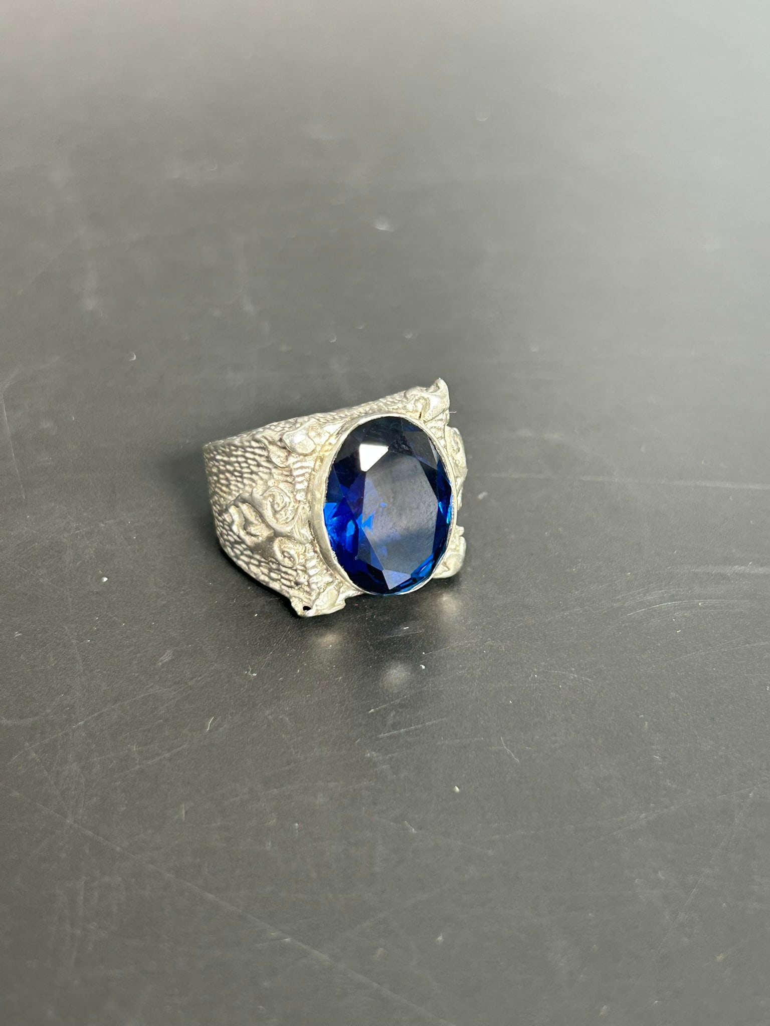 A Blue Stone Inset Ring: Illegible marks to the interior. 1.1/8 in. long, 7/8 in. wide.