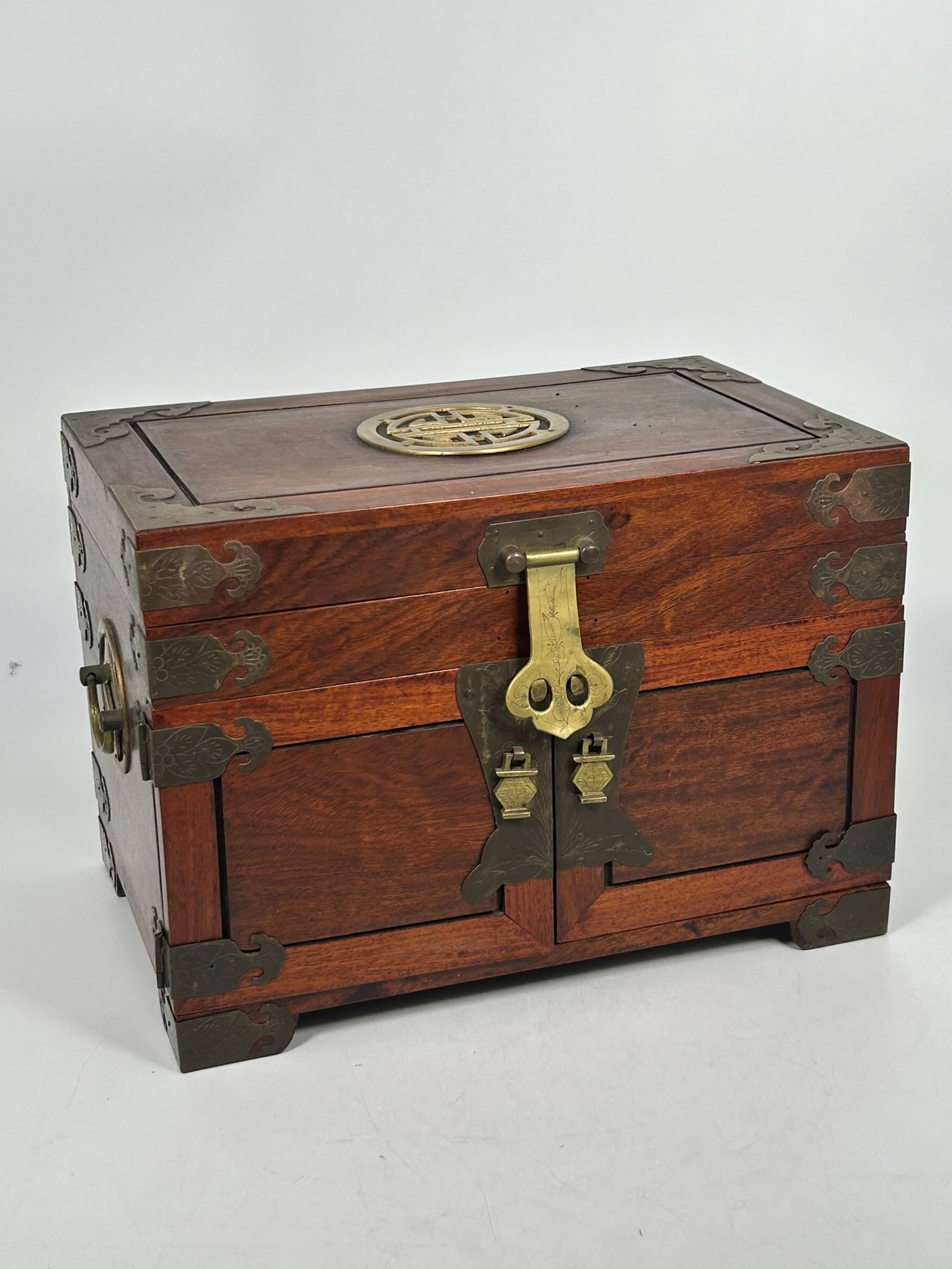 A Chinese Wood and Brass Jewelry Box: 9.3/4 in. high, 14 in. wide, 9 in. deep.