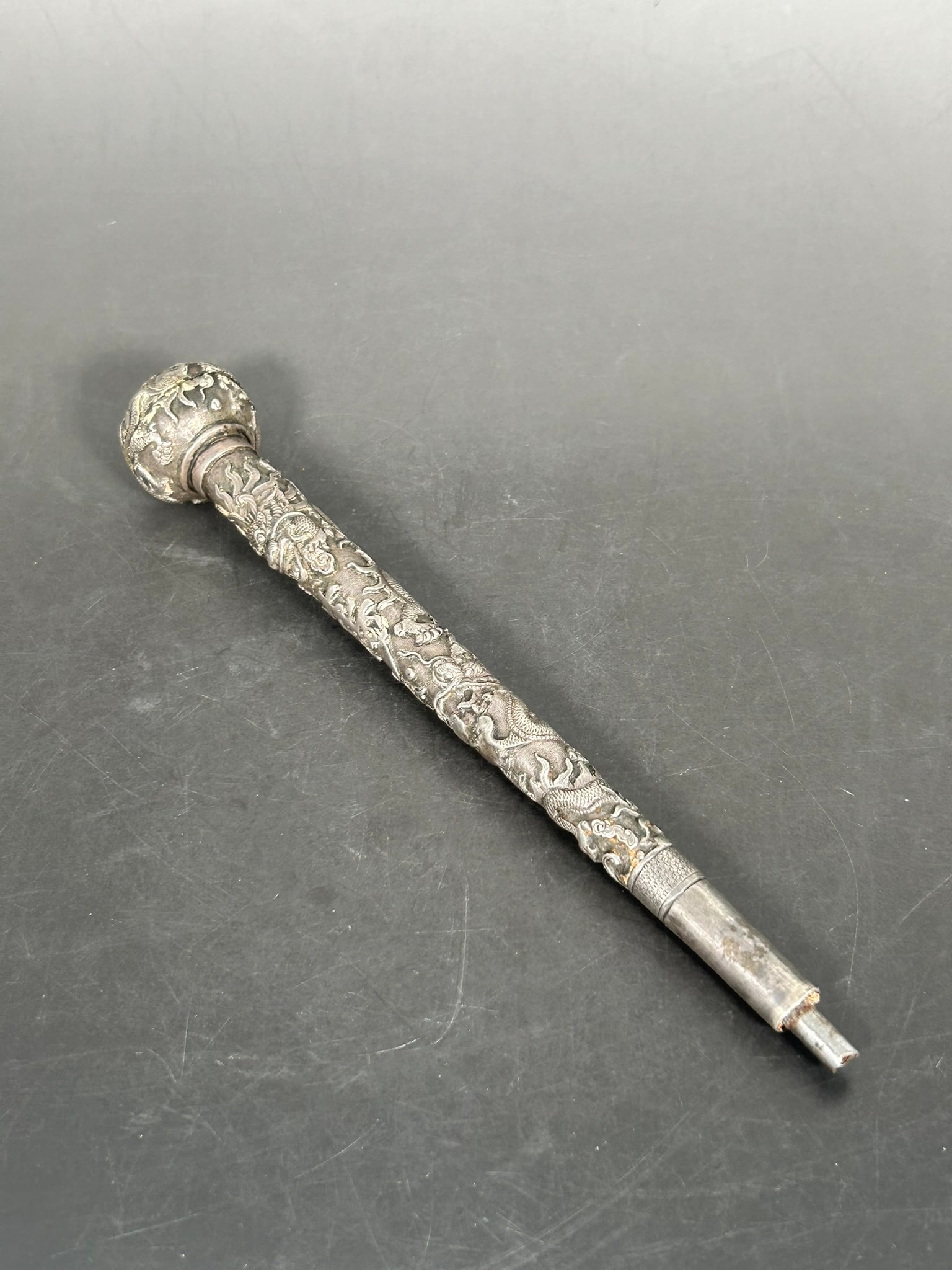 A Chinese Carved Silver 'Dragon, Fu, and Shou Characters' Walking Stick Handle: 9.3/8 in. long, 1.1/2 in. wide.