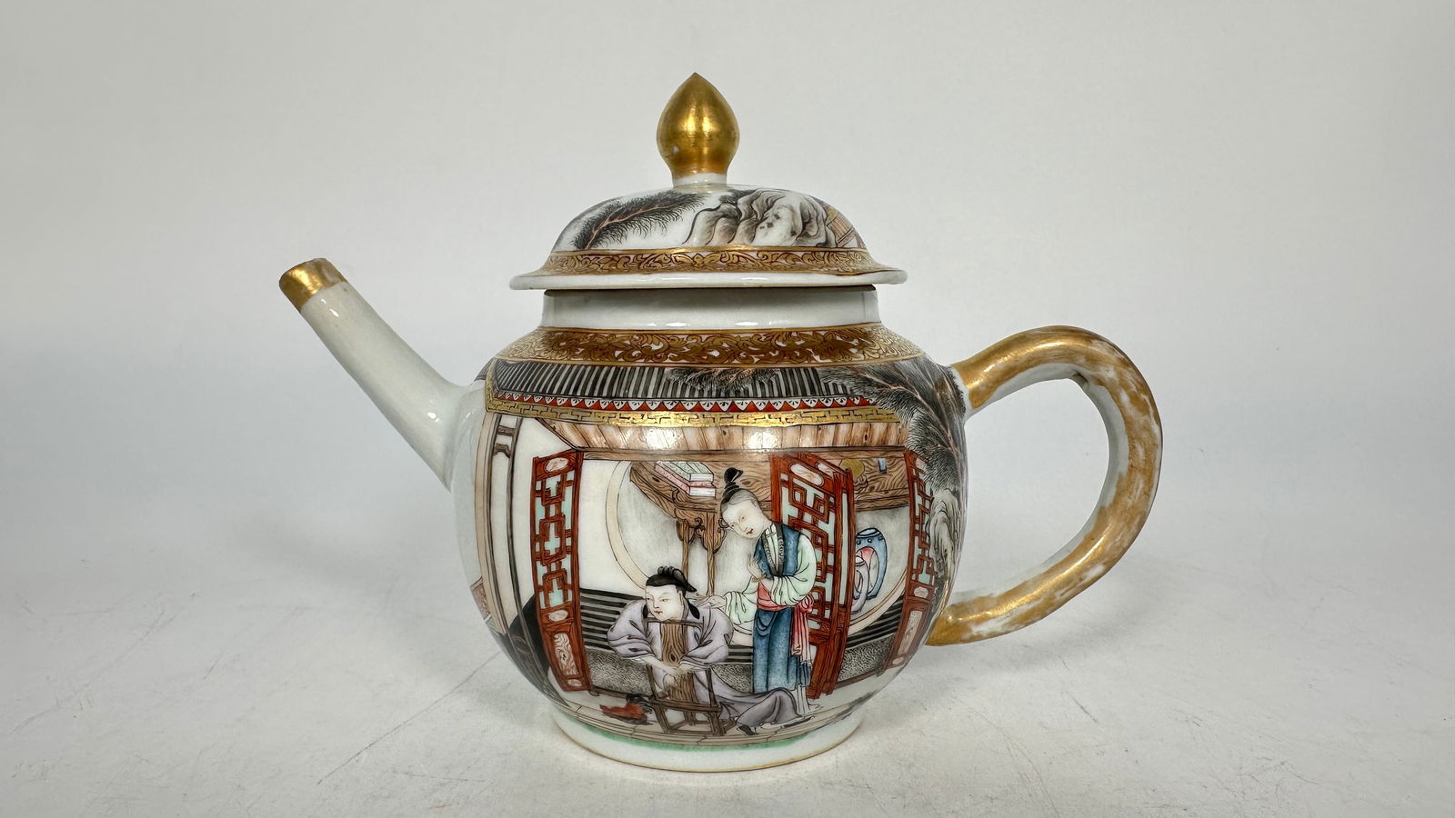 A Chinese Famille-Rose Gilt-Decorated Teapot, 18th Century: Of globular form, painted in famille-rose enamels and heightened with gilt decoration.Width: 7 1/2 in.Height: 5 1/2 in.Condition: Overall good condition with minor gilt wear consistent with age.
