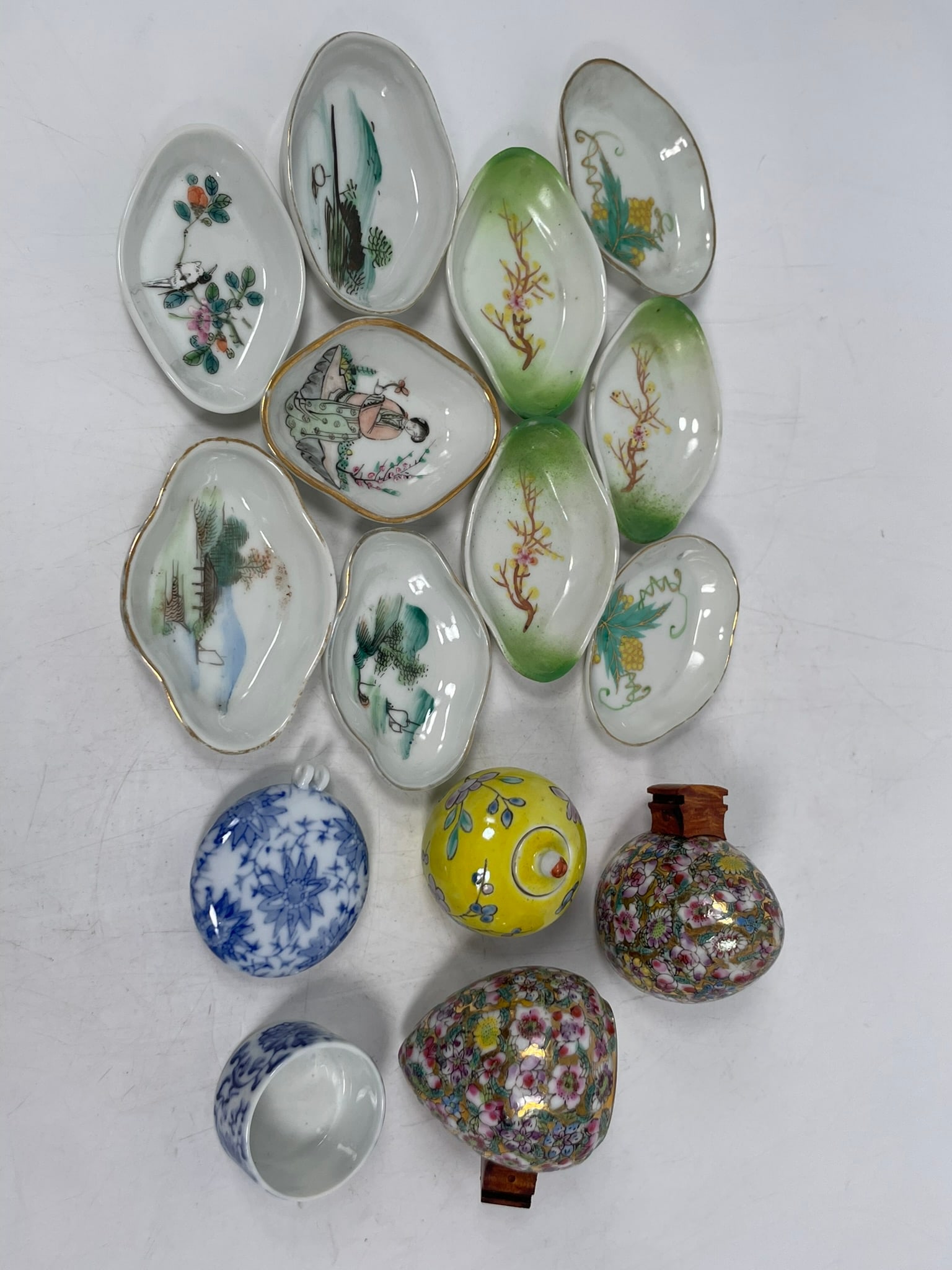 A Group of Fifteen Small Chinese Porcelain Ware: Comprising a pair of famille rose bird feeders, 2.1/4 in. high, 2.3/4 in. wide each; two blue and white bird feeders, with the wider one measures 2.3/8 in. wide; a group of ten small dishes,
