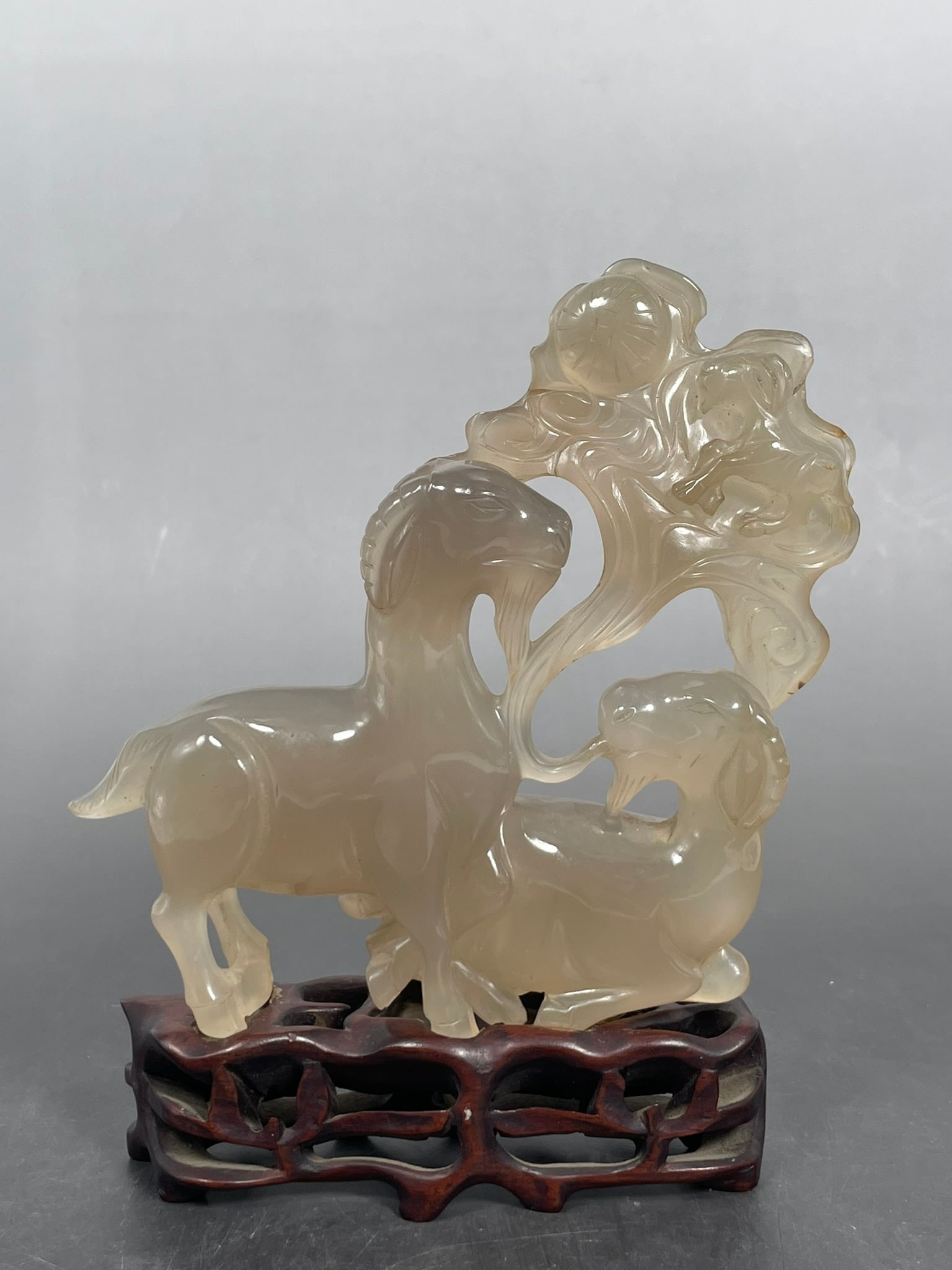 An Agate Carving Group of Two Goats: With a wood stand, the carving group measures 5.1/2 in. high, 5.1/2 in. wide. Property of a Private Maryland Collector.
