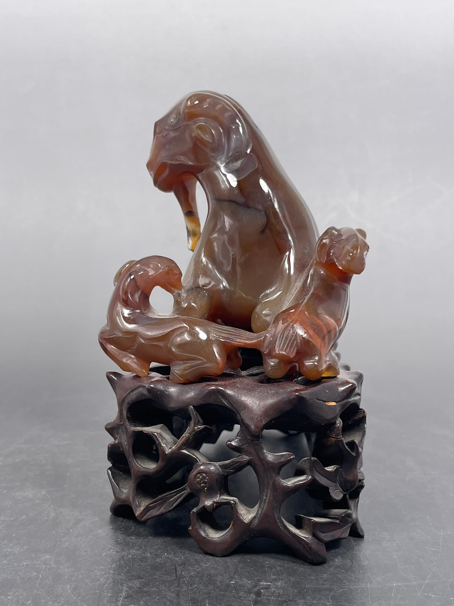 An Agate Carving Group of Three Goats: With a wood stand, the carving group measures 3.1/2 in. high, 5.1/2 in. wide. Property of a Private Maryland Collector.