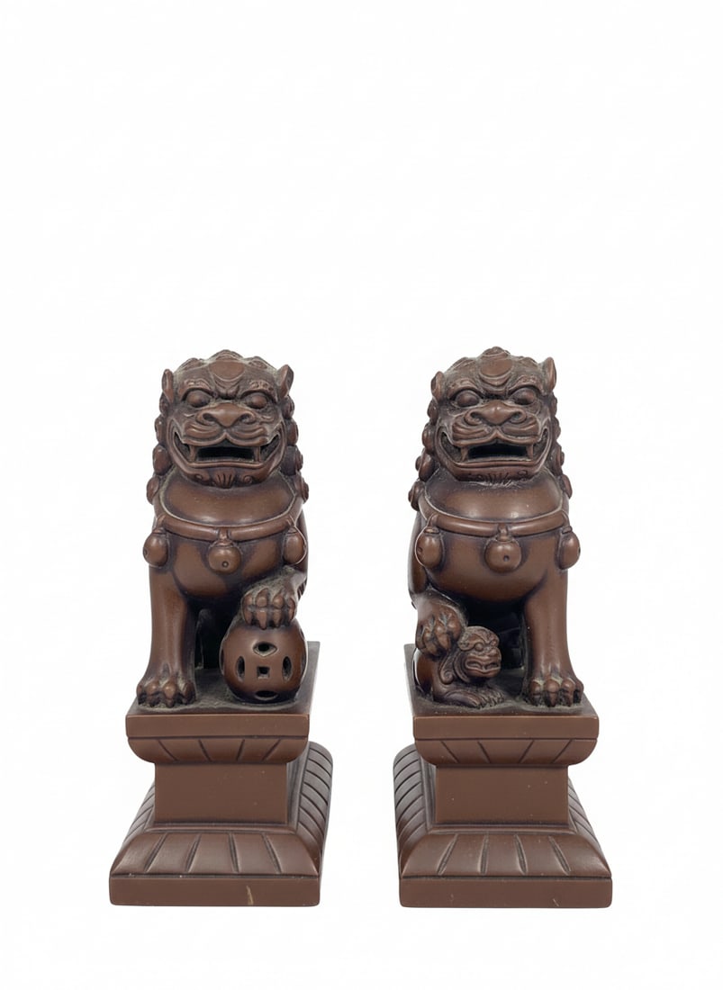 A Pair of Resin Figures of Buddhist Lions: 6.3/4 in. high, 4.3/8 in. wide each.