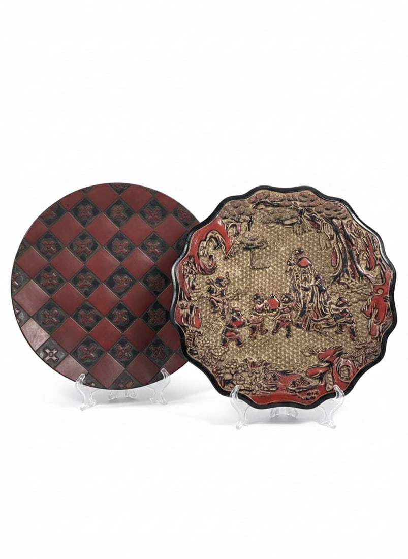 Two Wood Dishes: Comprising a carved wood 'shoulao and boys' dish, 11 in. wide; and a black and red-painted dish, 10.5/8 in. diam.