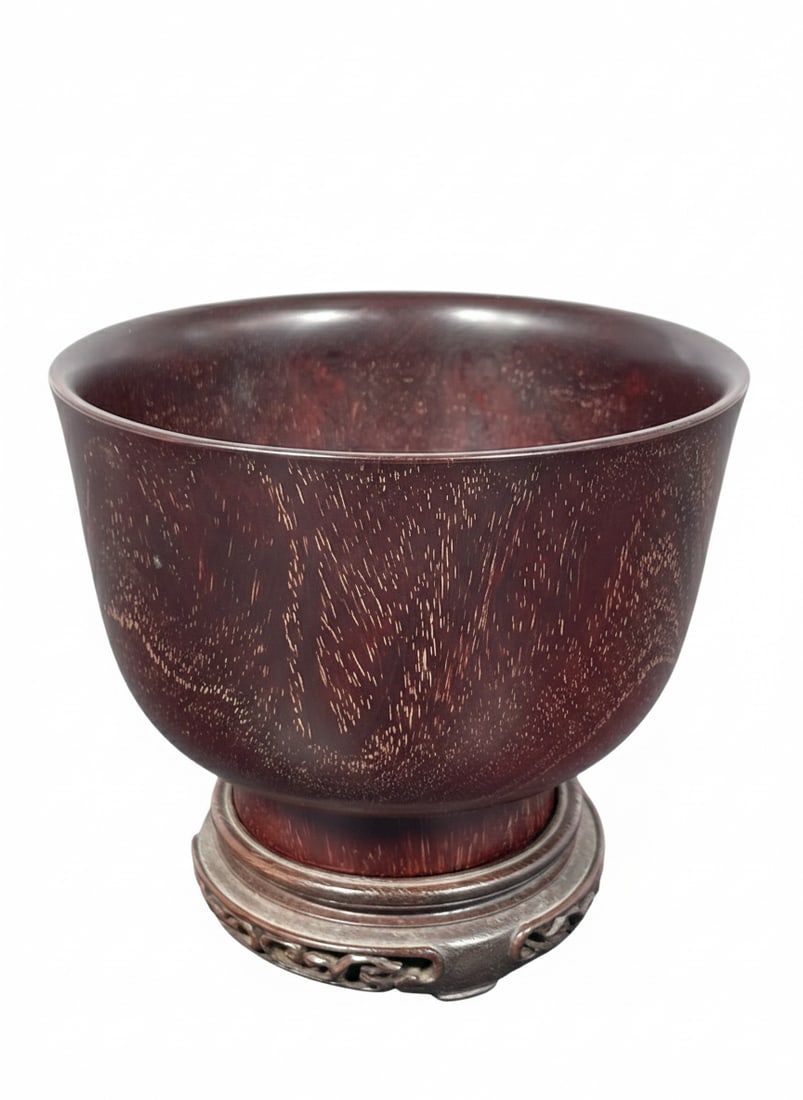 A Dark Wood Bowl: With a wood stand that contains a Christie's sticker. The bowl measures 3.1/2 in. high, 4.3/4 in. diam.