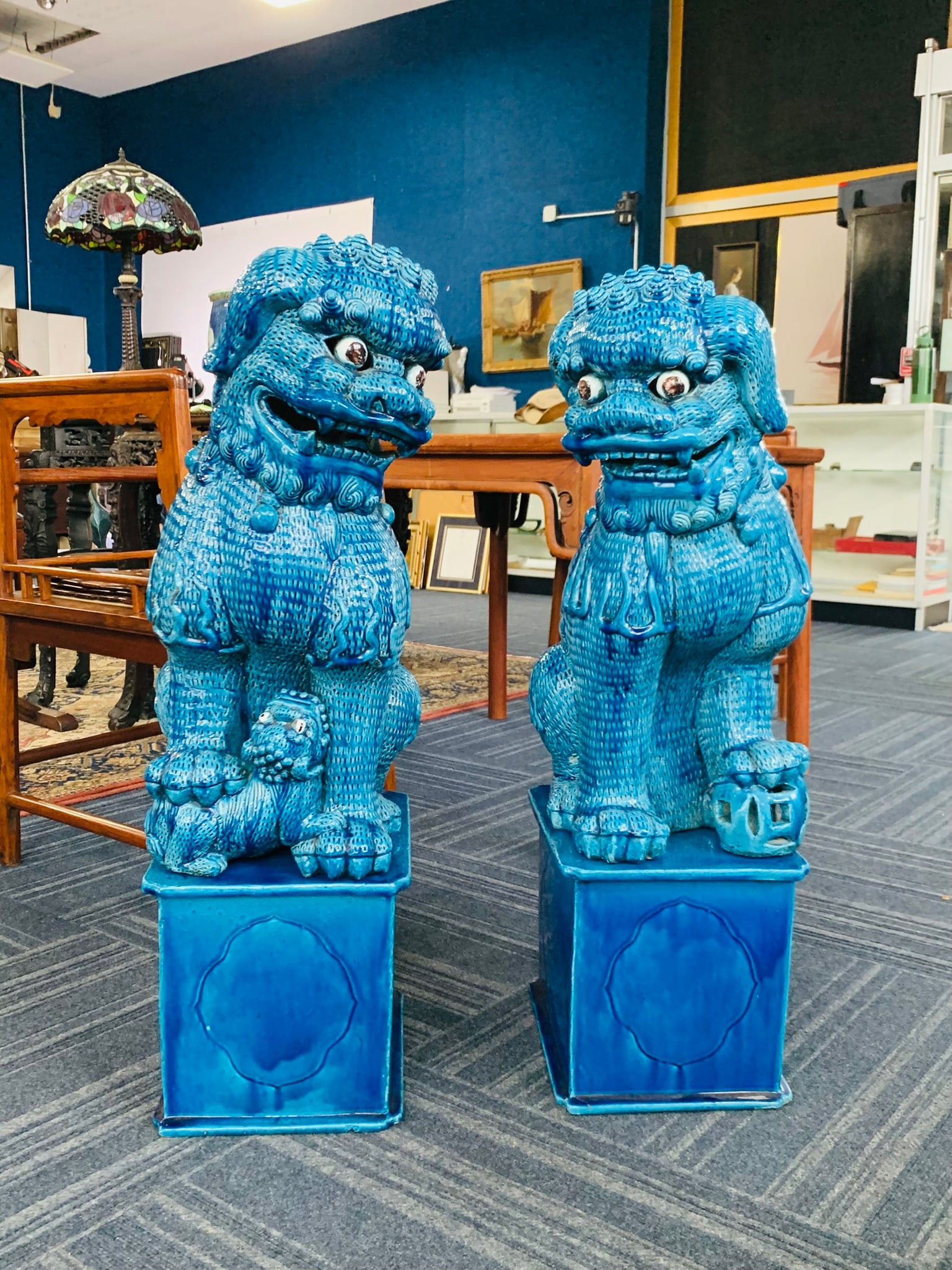A Pair of Chinese Large Turquoise-Glazed Figures of Buddhist Lions: Both with turquoise-glazed stands, 23 in. high, 16.1/2 in. wide each for the figures; 10.1/2 in. high, 13 in. wide each for the stands.