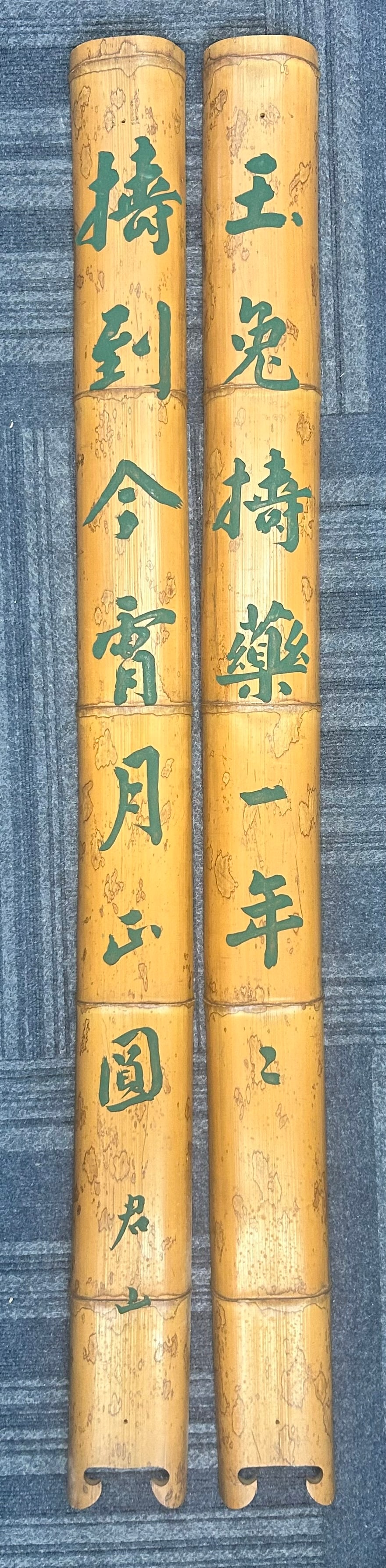 A Pair of Chinese Carved Bamboo Panels: Featuring green calligraphy writing, with a signature of the artist. 54.1/2 in. long, 4 in. wide each.