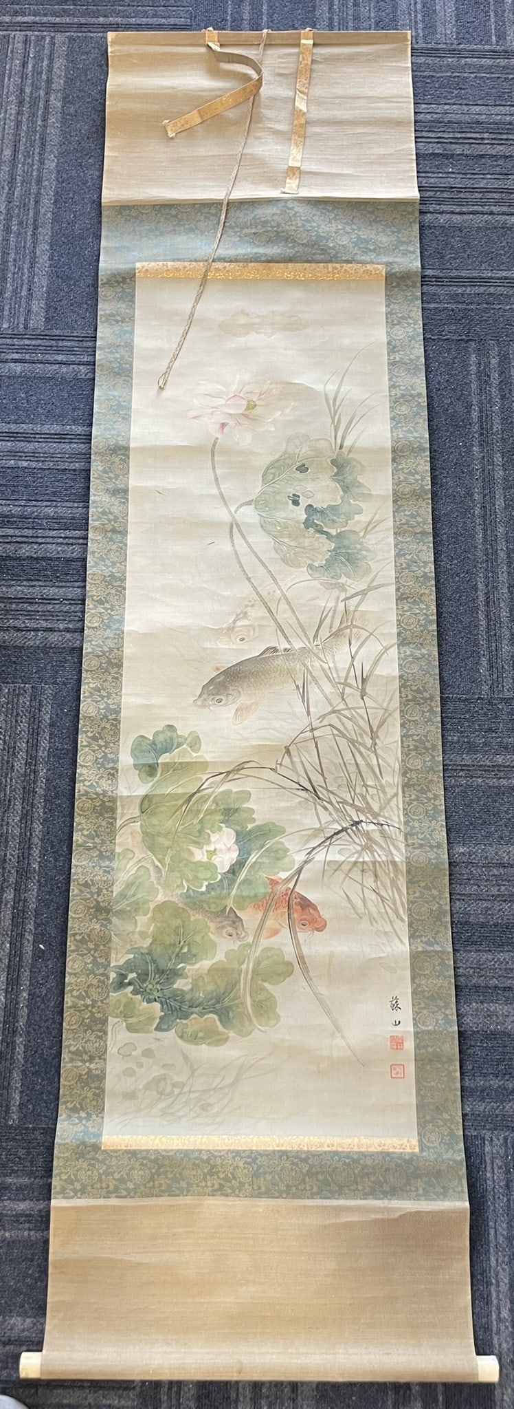 A Japanese Painting of Koi Fish, Artist's Signature: Mounted as a hanging scroll, ink and color on silk, signature of the artist to the right side, 52.1/2 in. x 16.1/4 in. for the painting, 83 in. x 21 in. overall.