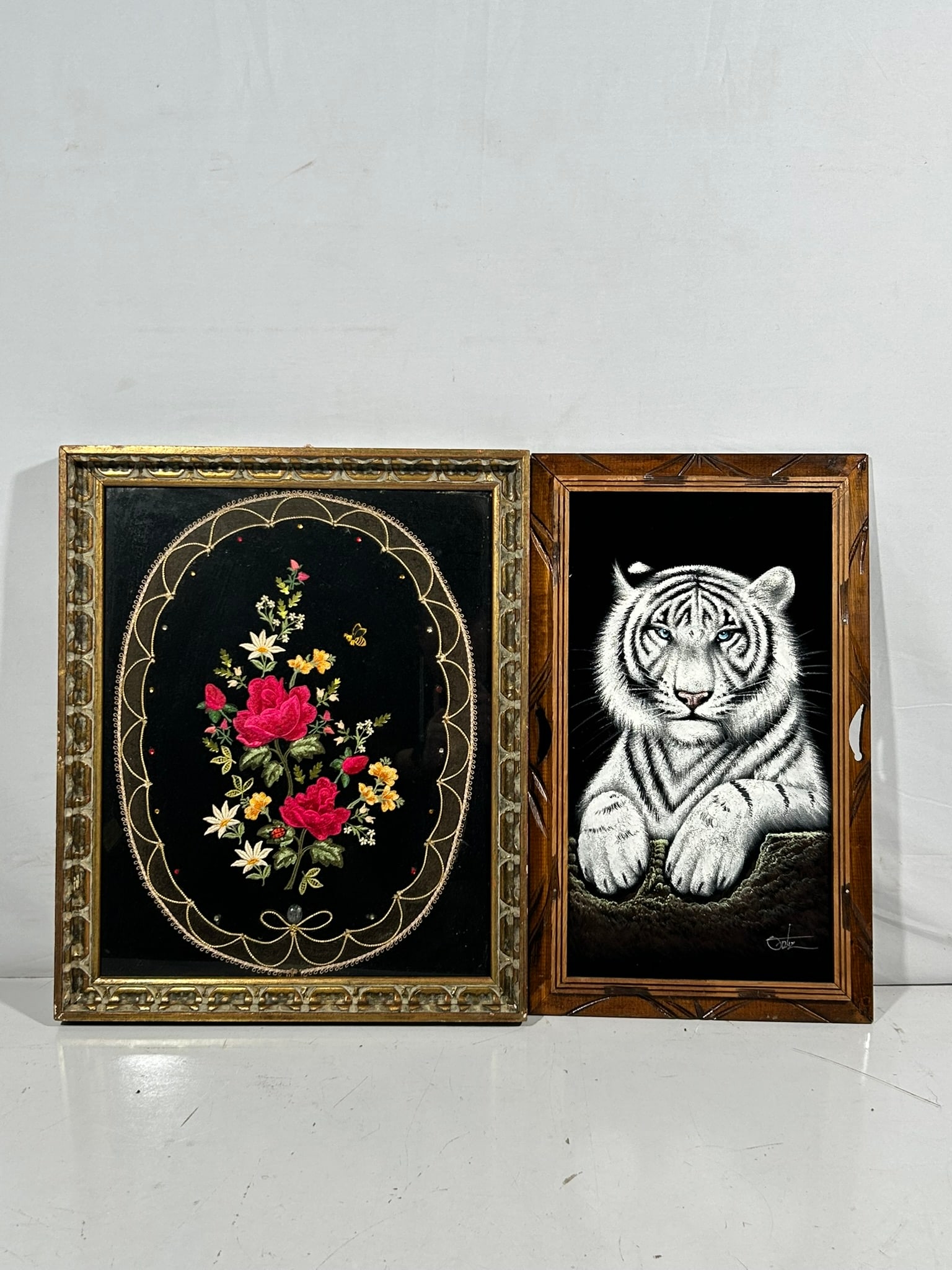 Two Textile Art Objects: Comprising a vintage crewel embroidery flower bouquet, bee, and ladybug, 22.1/2 in. x 18.1/2 in. overall including the frame; and a hand-painted white tiger on black velvet, a signature David Ortiz to