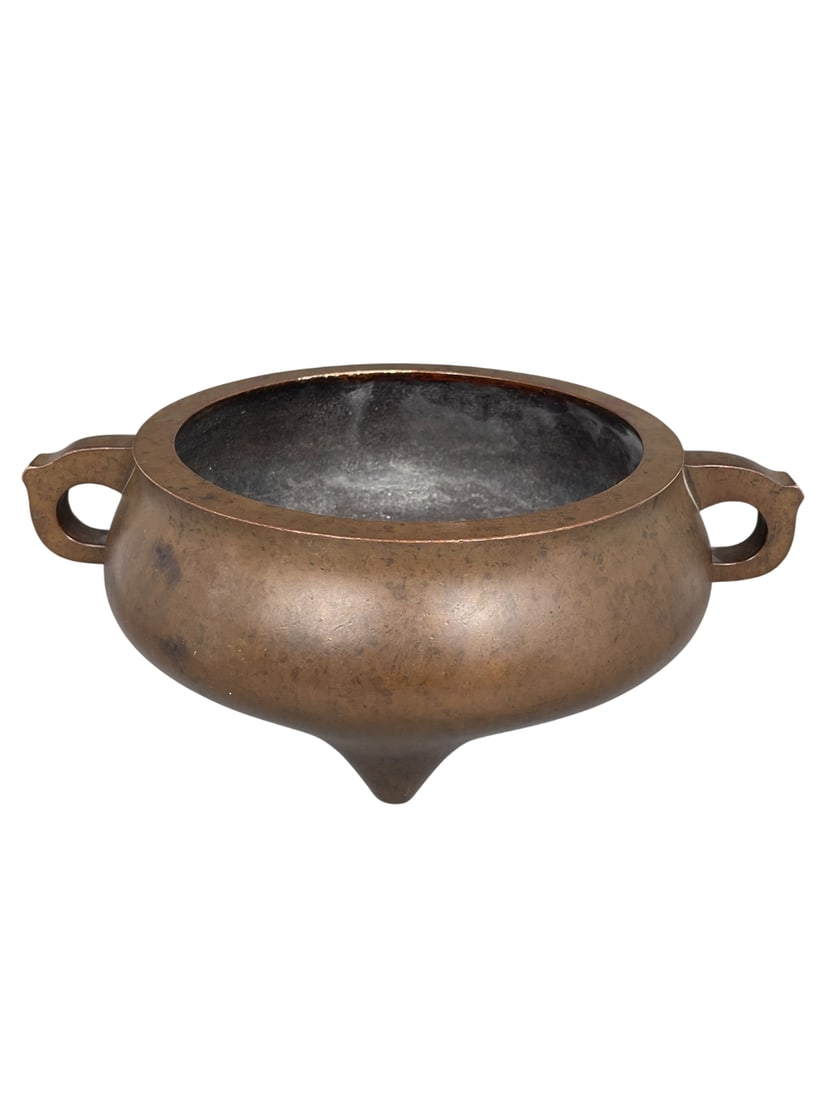 A Chinese Bronze Tripod Censer: With an apocryphal Dehua mark to the underside. 3.5/8 in. high, 10 in. wide.