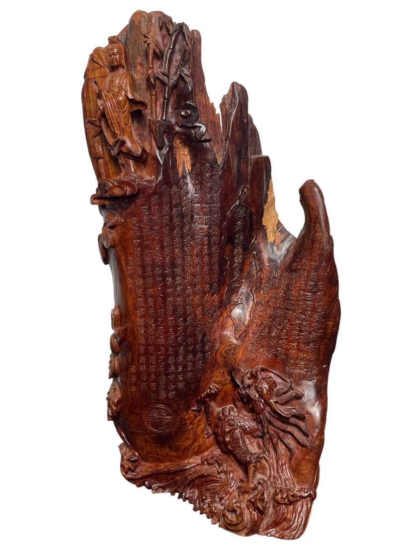 A Chinese Carved Wood Sculpture of Guanyin and Rock: Carved with inscription Heart Sutra, and a date the year of Ren Wu (1942 or 2002). 31 in. high, 15 in. wide. Private Collection of the Huang Family.