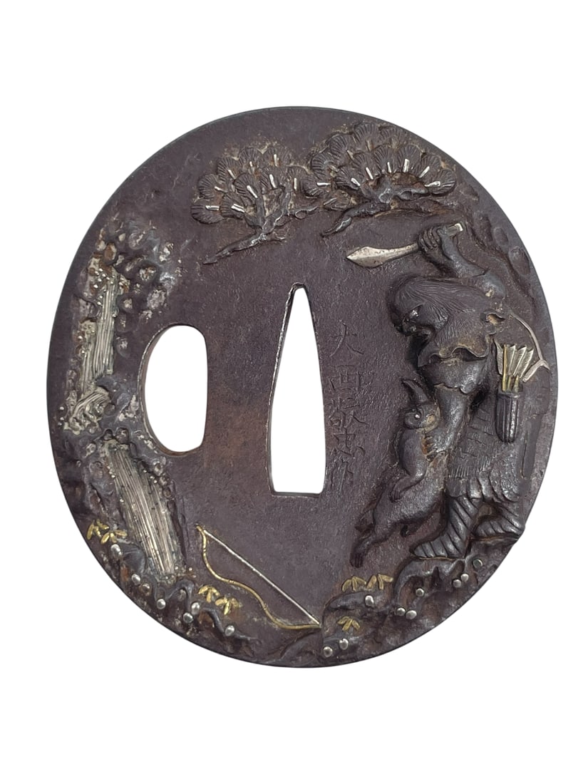 A Japanese Samurai Sword Guard, Tsuba, Maker's Mark: Maker's mark probably reads 'Onishi Keichu' to one side of the tsuba; 2.7/8 in. long, 2.5/8 in. wide.