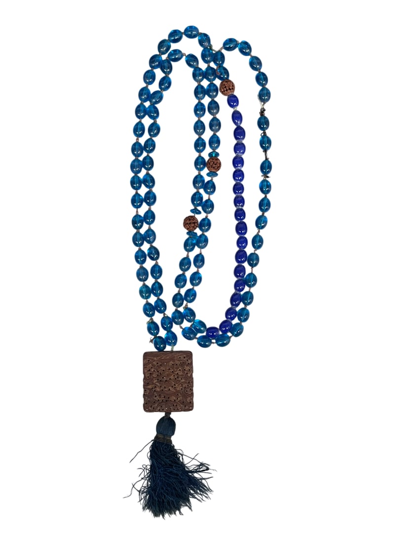 A Chinese Carved Agarwood Plaque: Attached to a string of glass beads together as a necklace. The plaque measures 1.7/8 in. long, 1.1/2 in. wide.