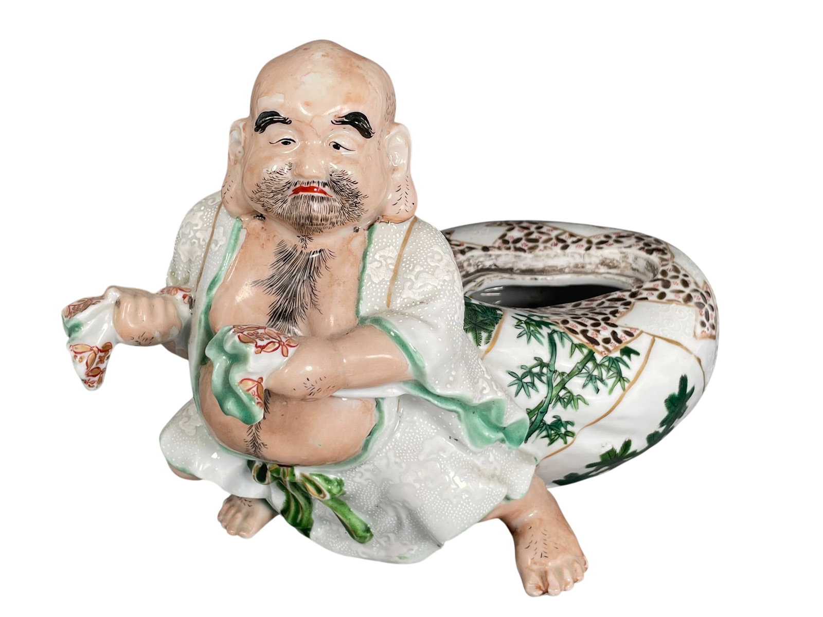 A Chinese Famille Rose Porcelain Brush Pot in the Shape of Luohan, 19th Century: 6.1/2 in. high, 9.1/2 in. wide.