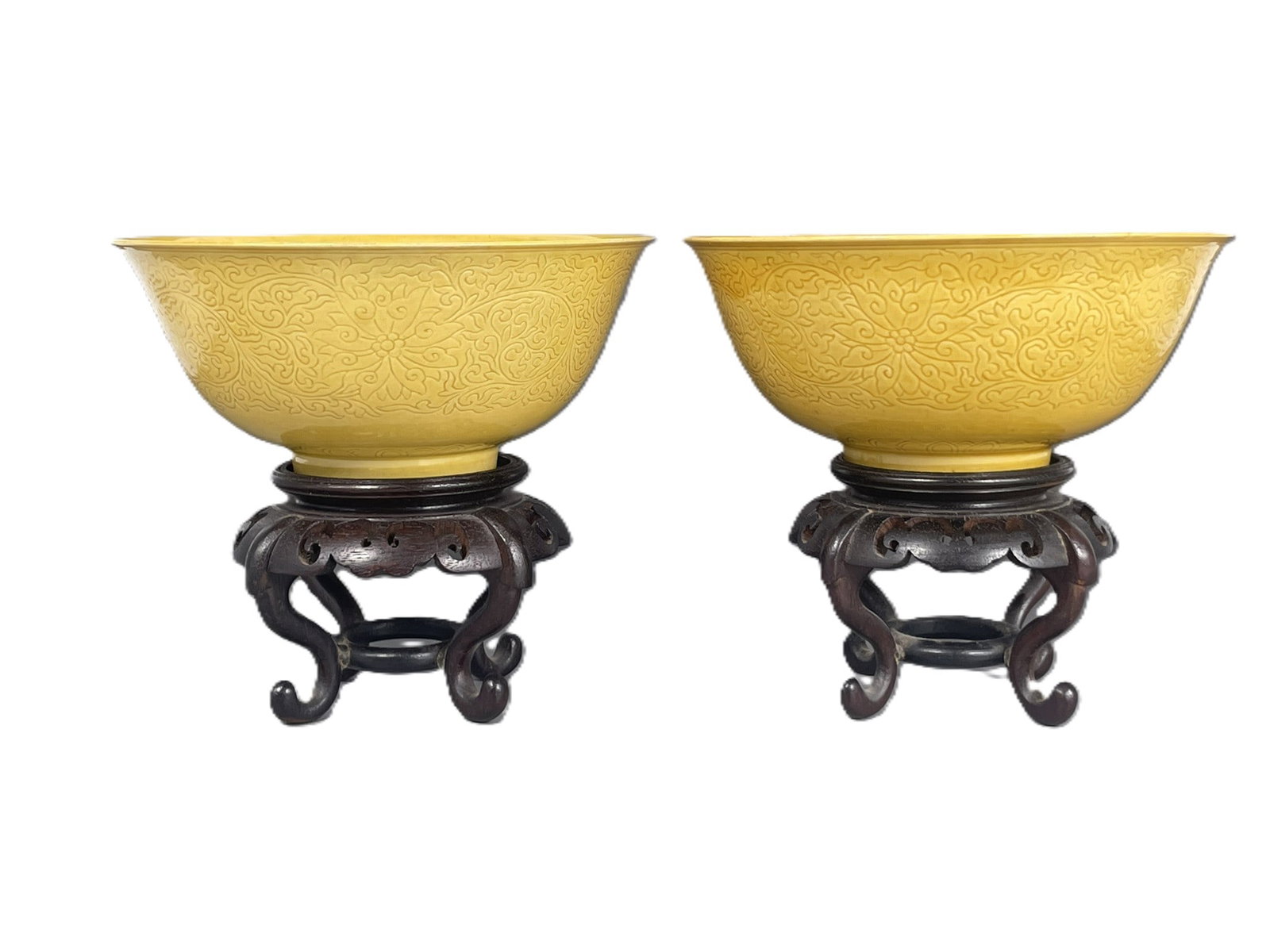 A Pair of Chinese Yellow-Glazed Incised Bowls: Both with wood stands. Apocryphal Chenghua marks to the undersides. The bowls measures 2.1/2 in. high, 5.3/8 in. diam. each.