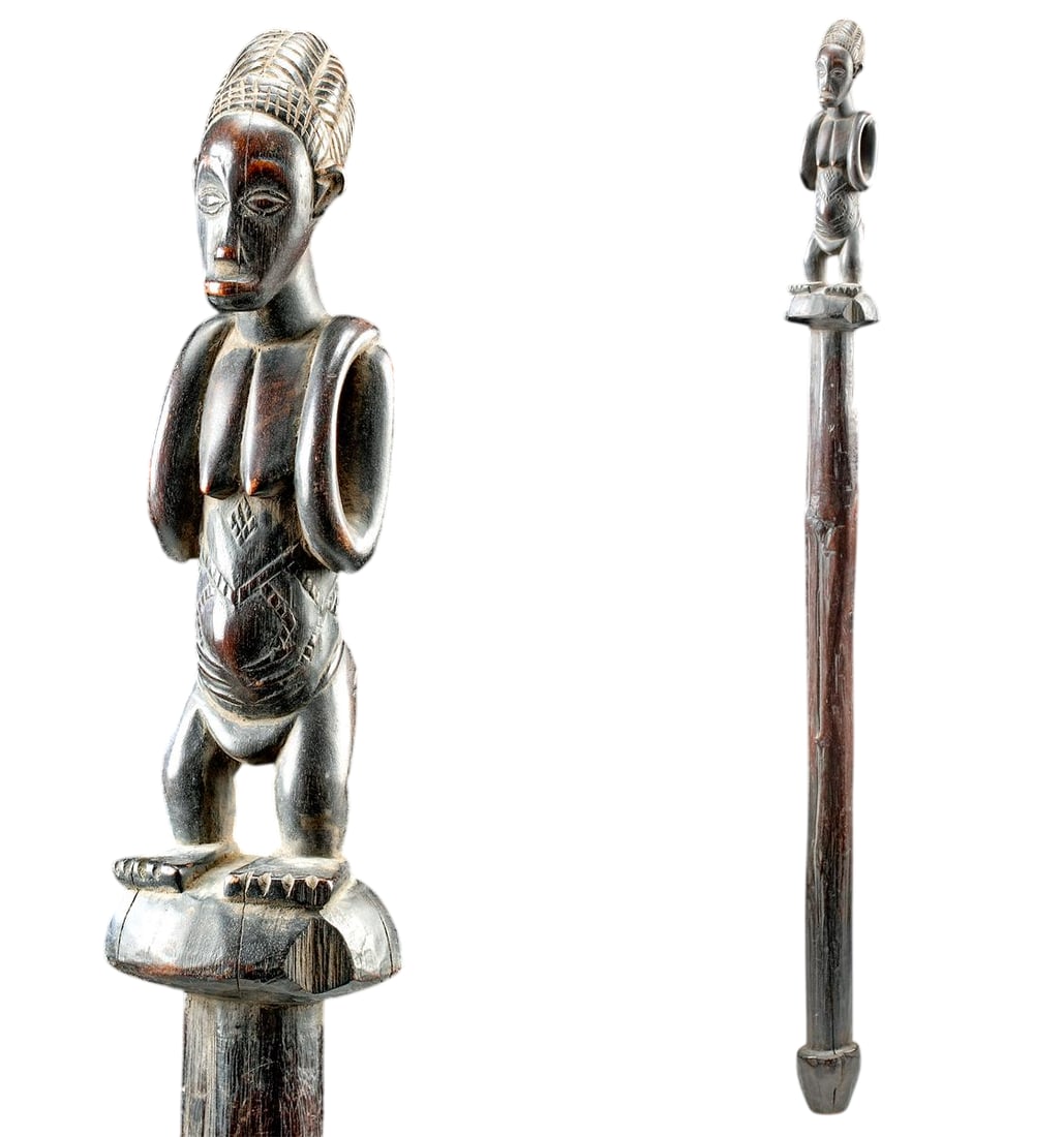 An African Wood Prestige Staff w/ Nude Female Finial, Late 19th to Early 20th Century: Central Africa, Democratic Republic of the Congo, Luba or Hemba culture, circa late 19th to early 20th century. A finely carved wooden staff surmounted by a nude female figure, her head crowned with a