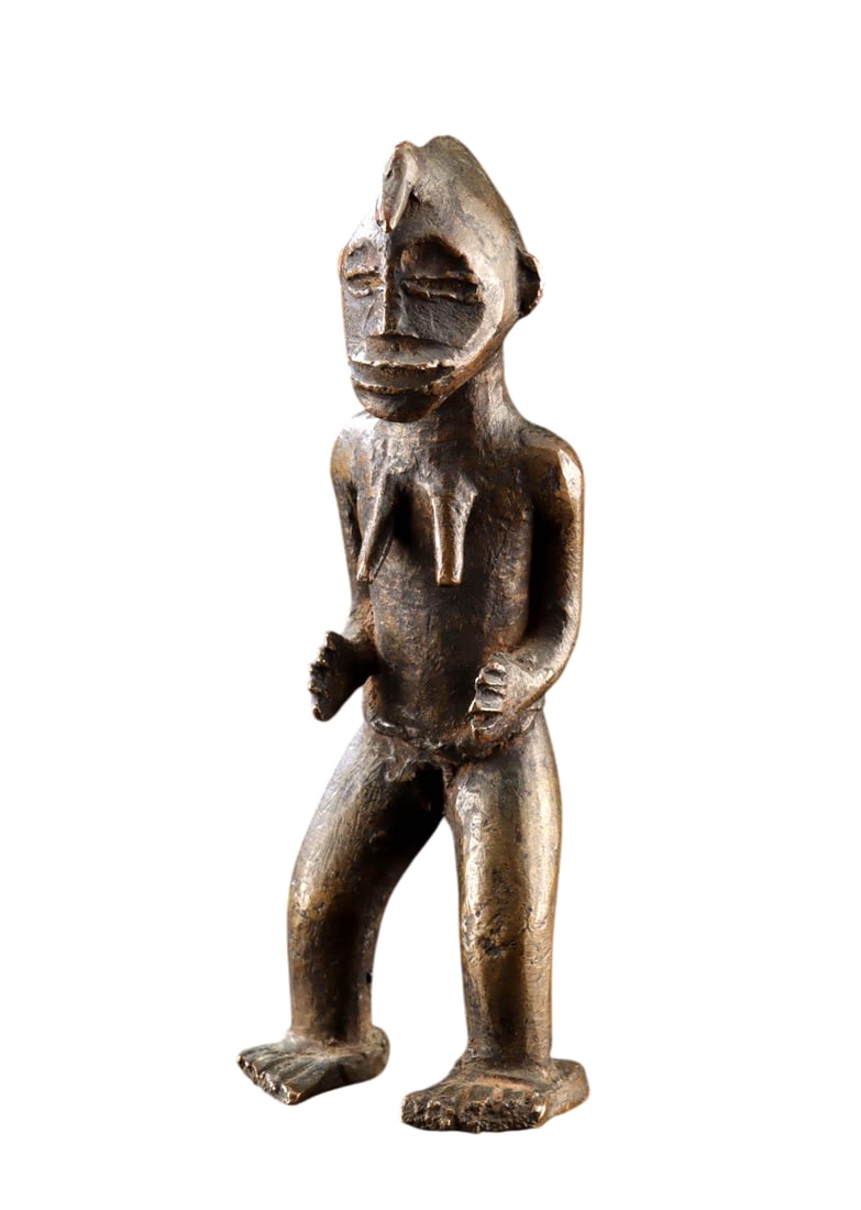An African Senufo Brass Standing Female Figure, Early to Mid-20th Century: West Africa, Burkina Faso or Cote d'Ivoire, Senufo culture, circa early to mid-20th century. A finely cast brass figure depicting a standing nude female with a distinctive crested coiffure. The figure