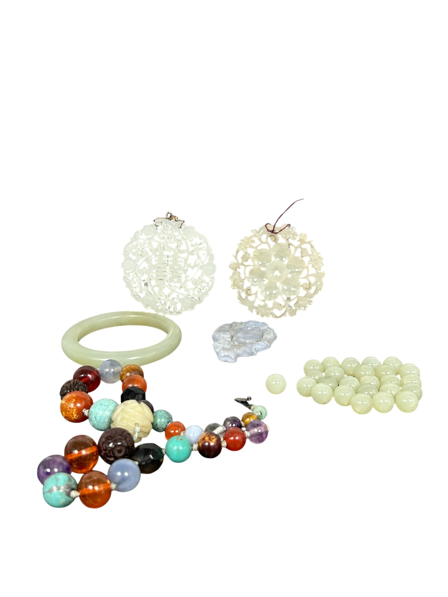 A Group of Six Items: Comprising a jade bangle, 2.1/2 in. diam.; two jade carved and reticulated plaques, with the slightly larger one measures 2.1/4 in. diam.; a jade lavender reticulated pendant, 1.7/8 in. high, 1.3/8