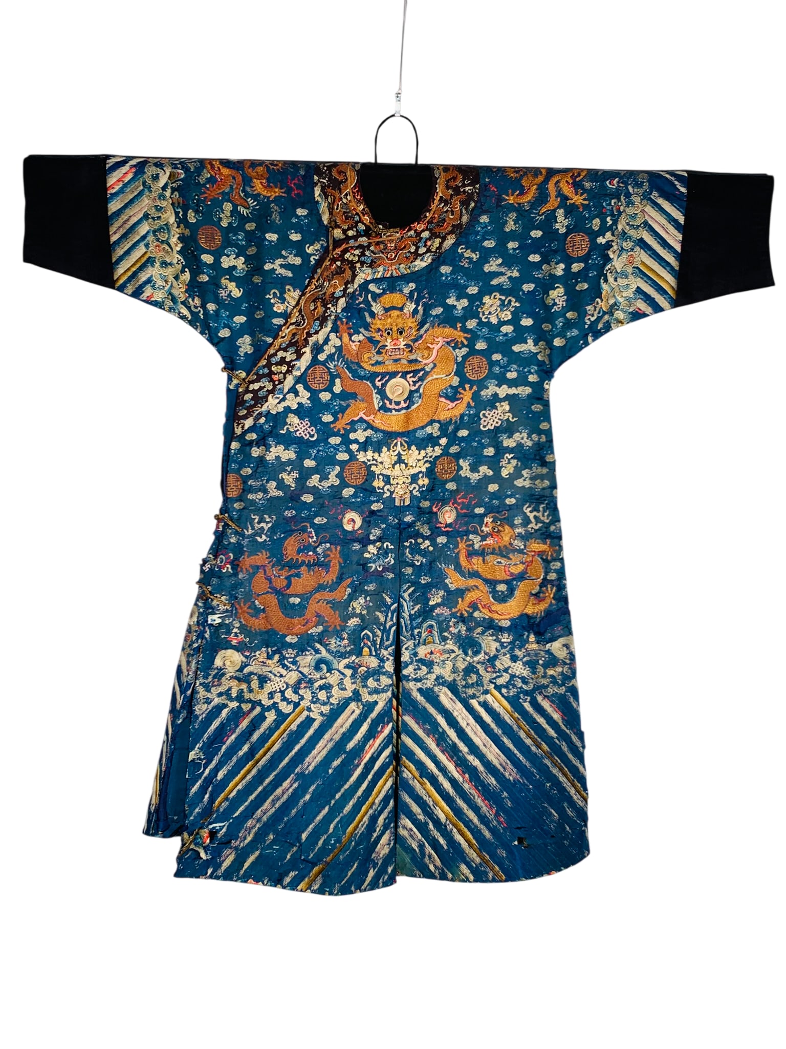 A Chinese Embroidered Blue-Ground Silk Robe: Featuring the prescribed nine five-clawed dragons, with two on the front and back clutching flaming pearls, while the remaining dragons reach toward the pearls amid ruyi-shaped clouds. 57 in. wide, 52
