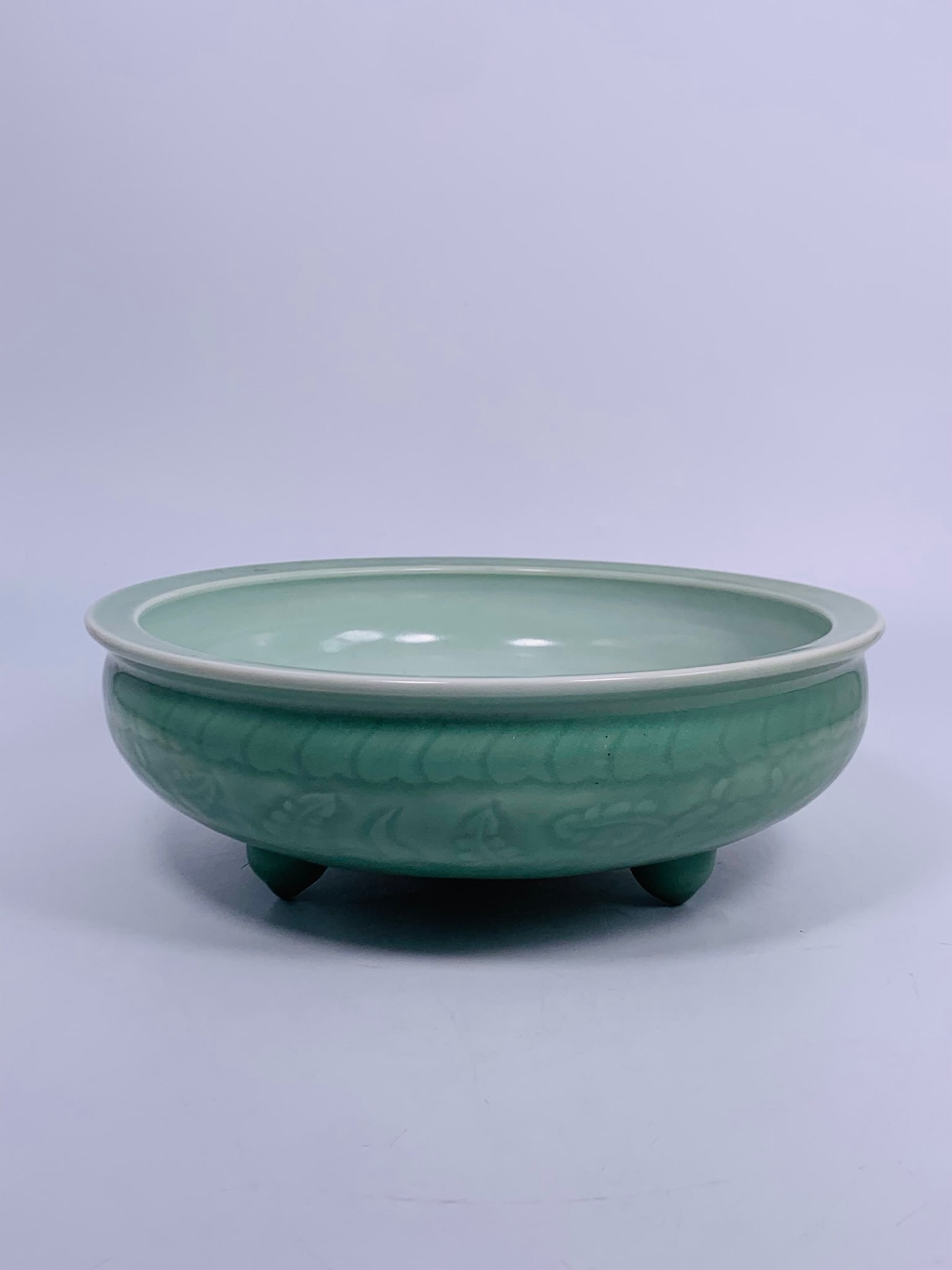 A Chinese Celadon-Glazed Porcelain Tripod Censer: 4.25 in. high, 12 in. diam.