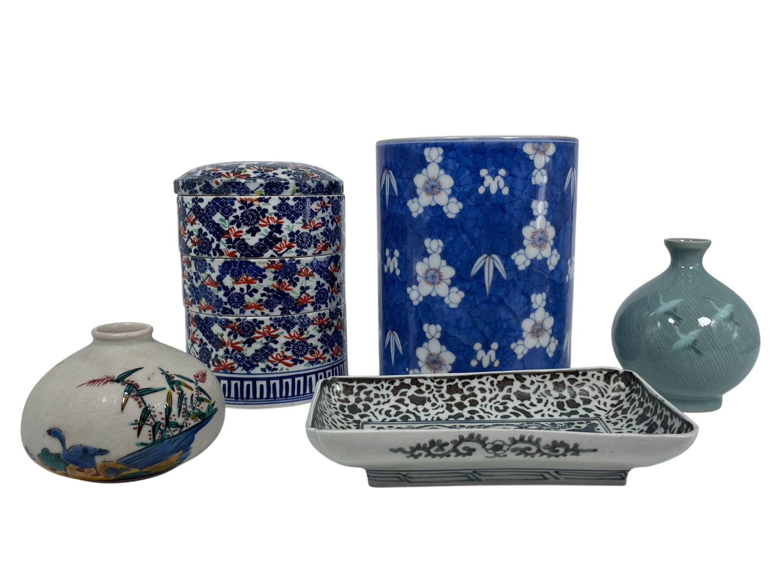 A Group of Five Japanese/Korean Porcelain/Pottery Ware: Comprising a blue and white iron-red-decorated brush pot, 7.1/2 in. high, 6 in. diam.; a blue and white 'rabbit' rectangular dish, 1.1/2 in. high, 8 in. wide; a three-tiered porcelain circular box and