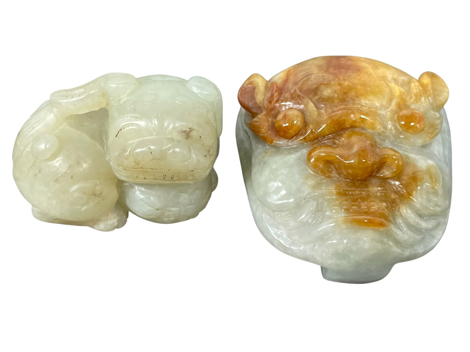 Two Small Chinese Carved Jade Ornaments: Comprising a carved jade figure of a buddhist lion, 1.1/4 in. high, 1.5/8 in. wide; and a mythical animal-shaped belt buckle, 2 in. high, 1.3/4 in. wide.