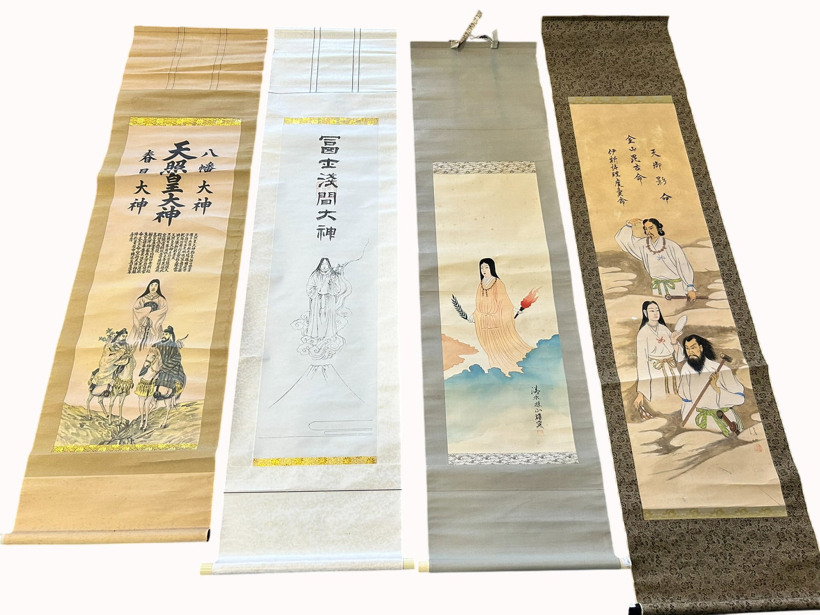 A Group of Four Japanese Paintings of Deities: Comprising a painting of Amaterasu-omikami, Hachiman, and Kasuga-no-Kami, 65 in. x 18 in. overall; a painting of Asama no Okami, 68 in. x 16.3/4 in. overall; a painting of a goddess, 65 in. x 17 in.