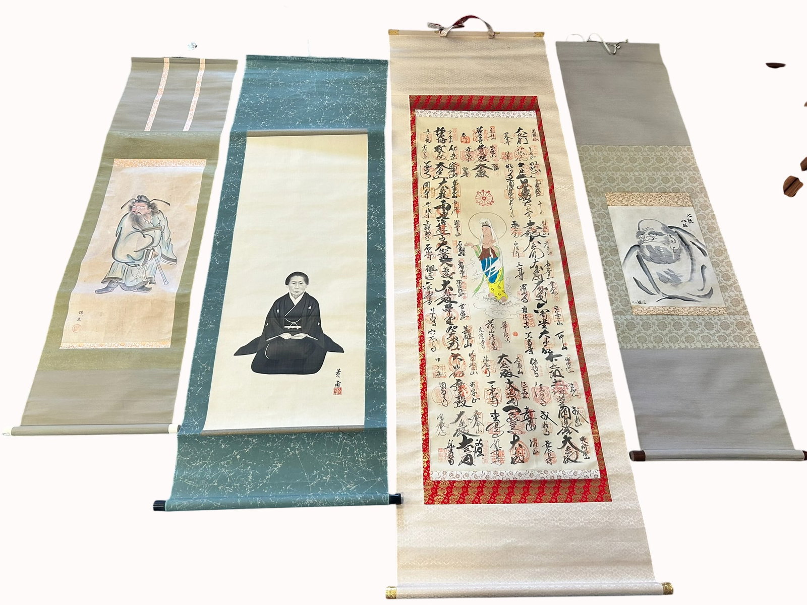 A Group of Four Japanese Paintings: Comprising a painting of Shoki, a signature of the artist and a seal, 56.1/2 in. x 15.1/2 in. overall; a painting of a lady, a signature of the artist and a seal, 64.1/2 in. x 21 in. overall; a